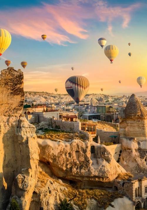 mongolfiere al tramonto sotto chiese rupestri