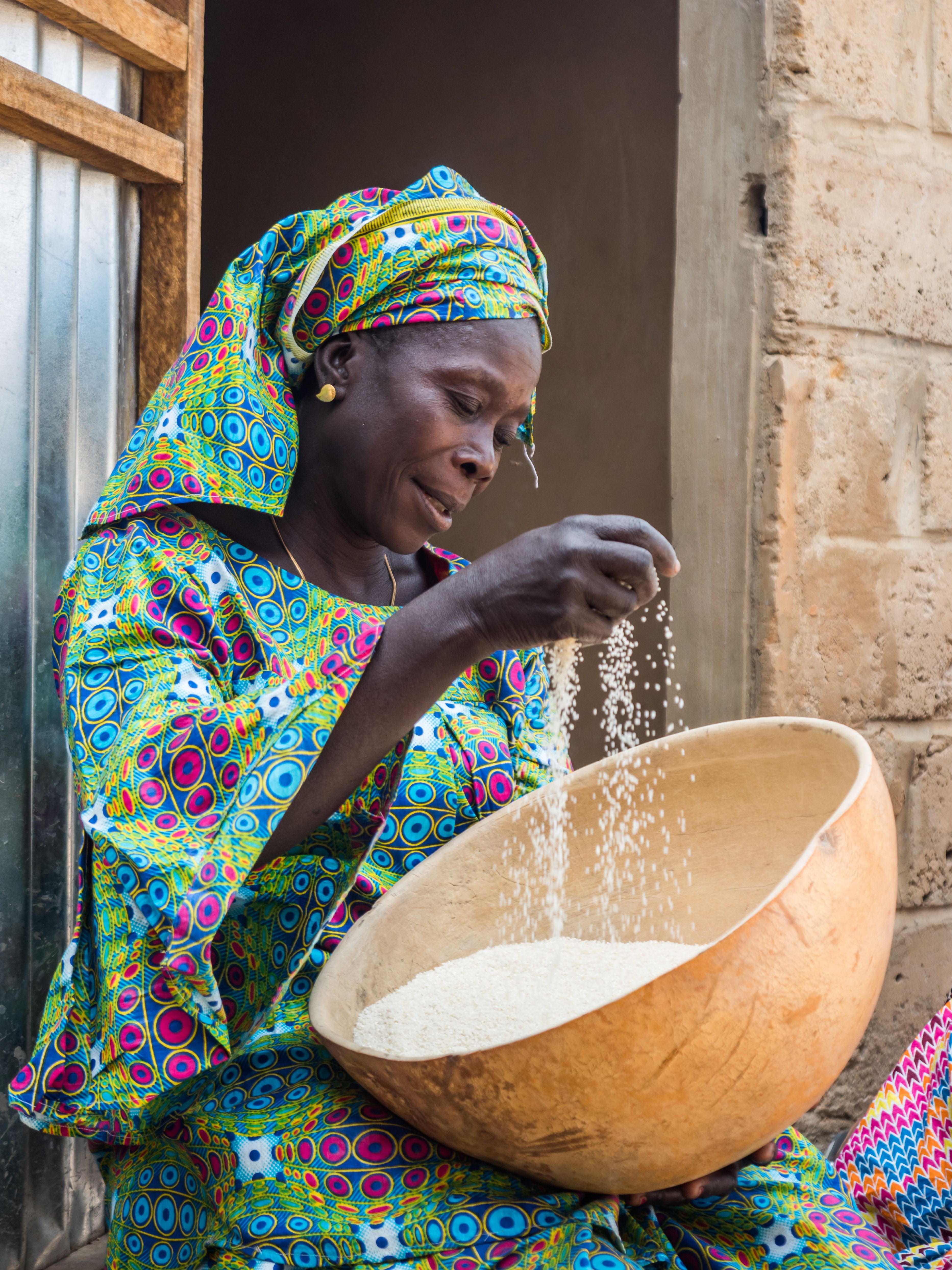 Senegalese woman processing rice in a bowl