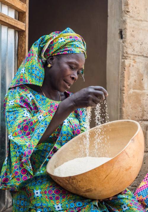 donna senegalese lavora il riso in una ciotola