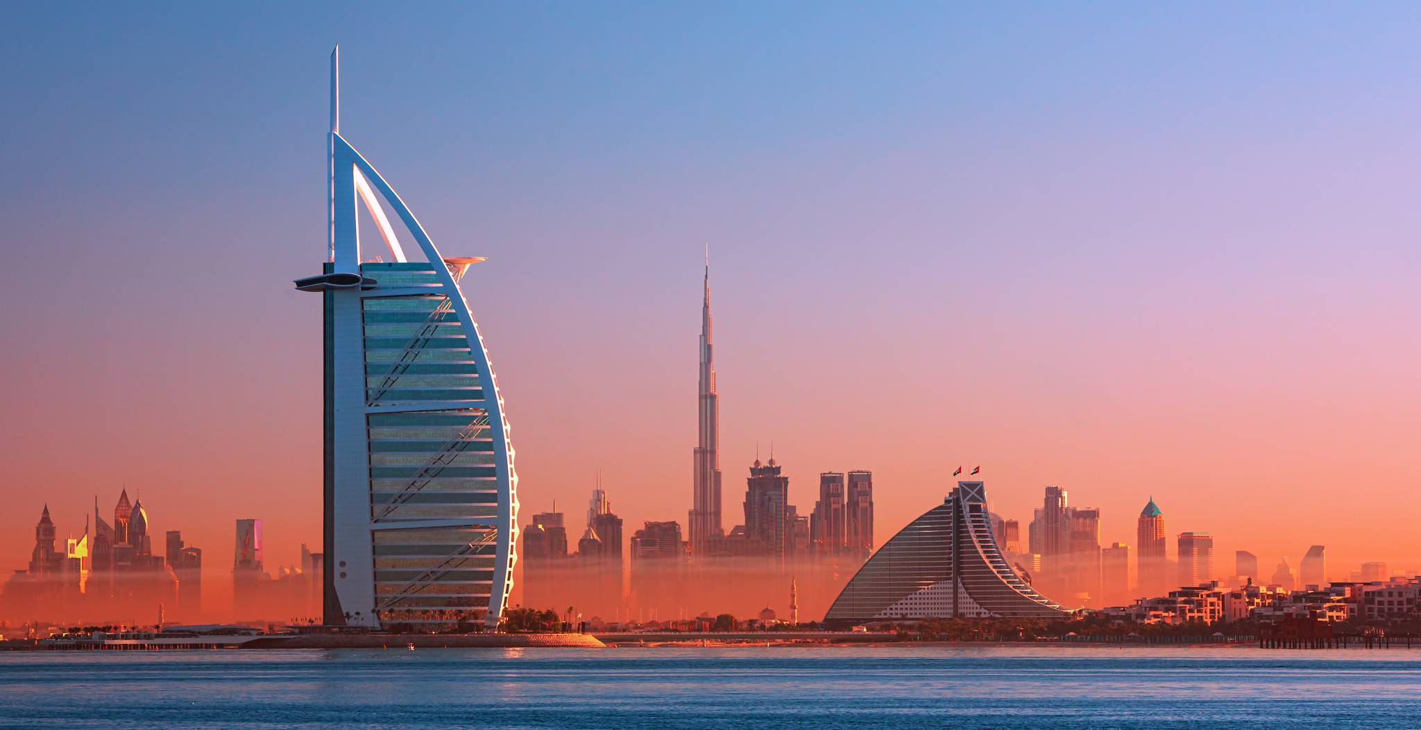 vista su dubai con la vela in primo piano al tramonto