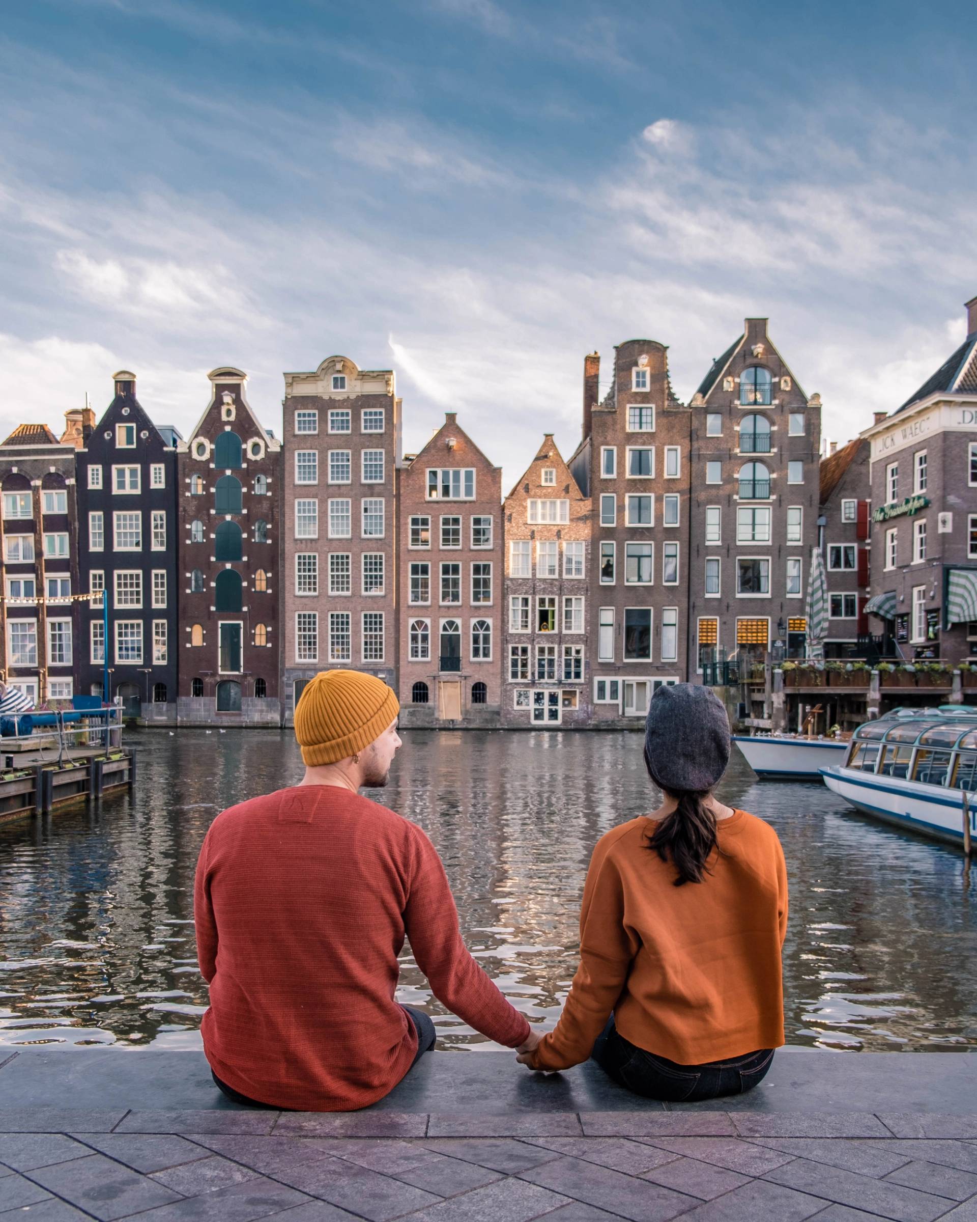 ragazzi di spalle che guardano il canale di amsterdam