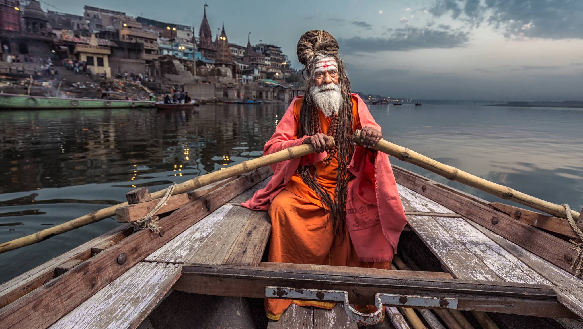 uomo su una barca sul fiume gange a varanasi