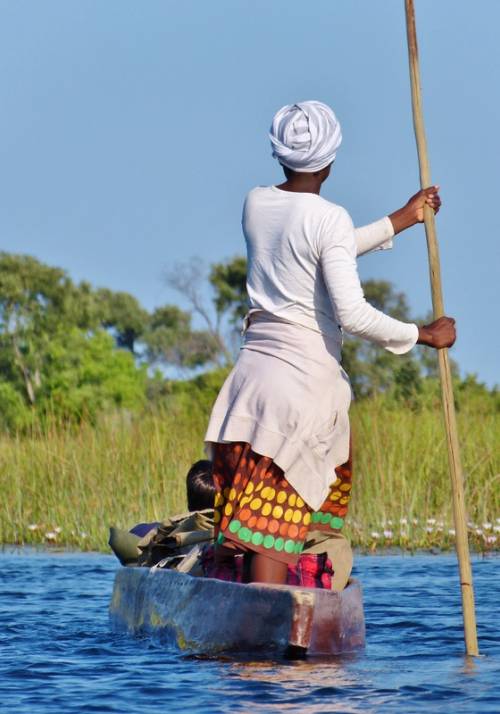uomo nativo in barca lungo il fiume