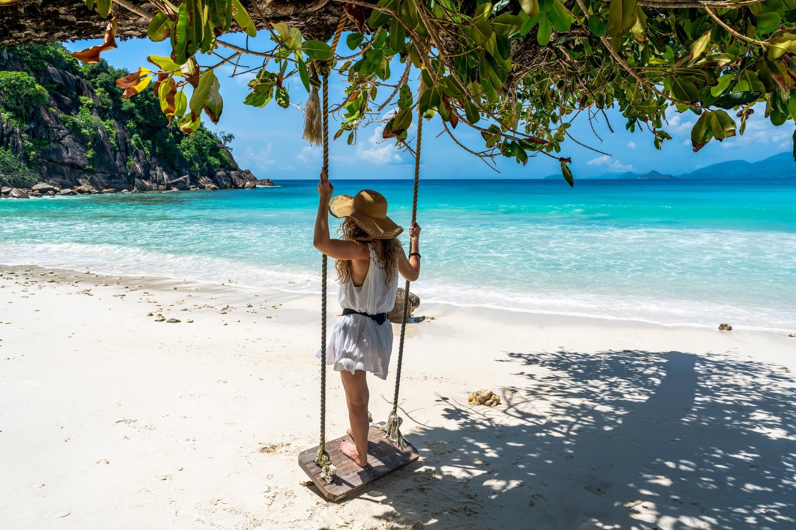 donna su altalena in spiaggia alle seychelles