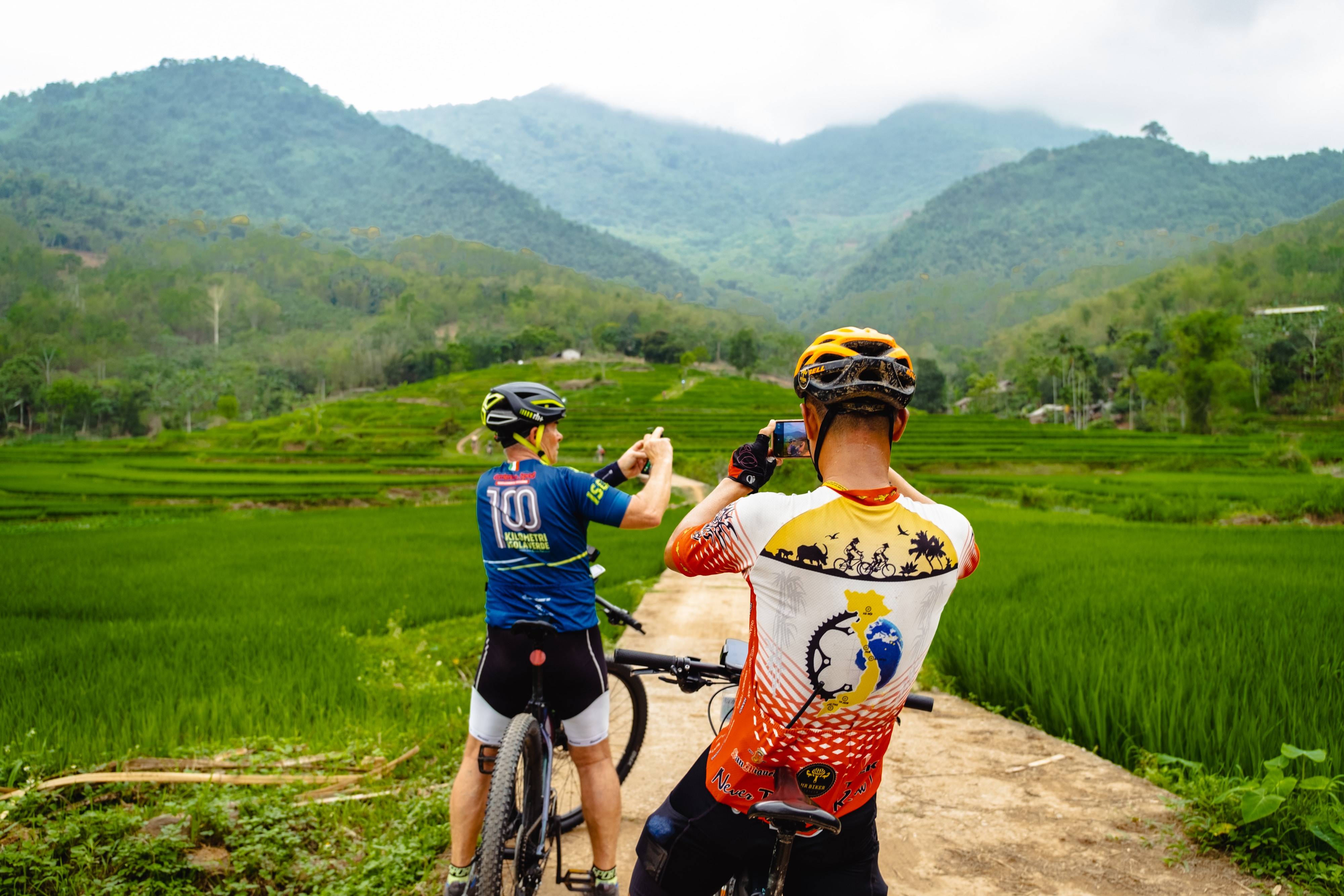 ciclisti lungo risaie del vietnam