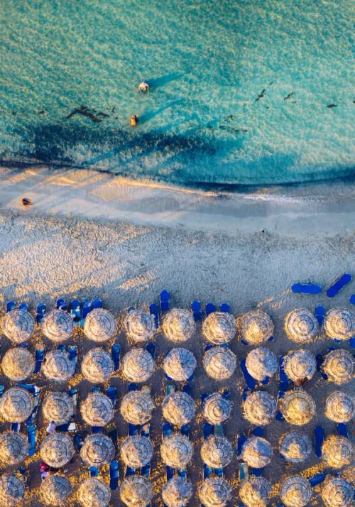 spiaggia con ombrelloni di paglia
