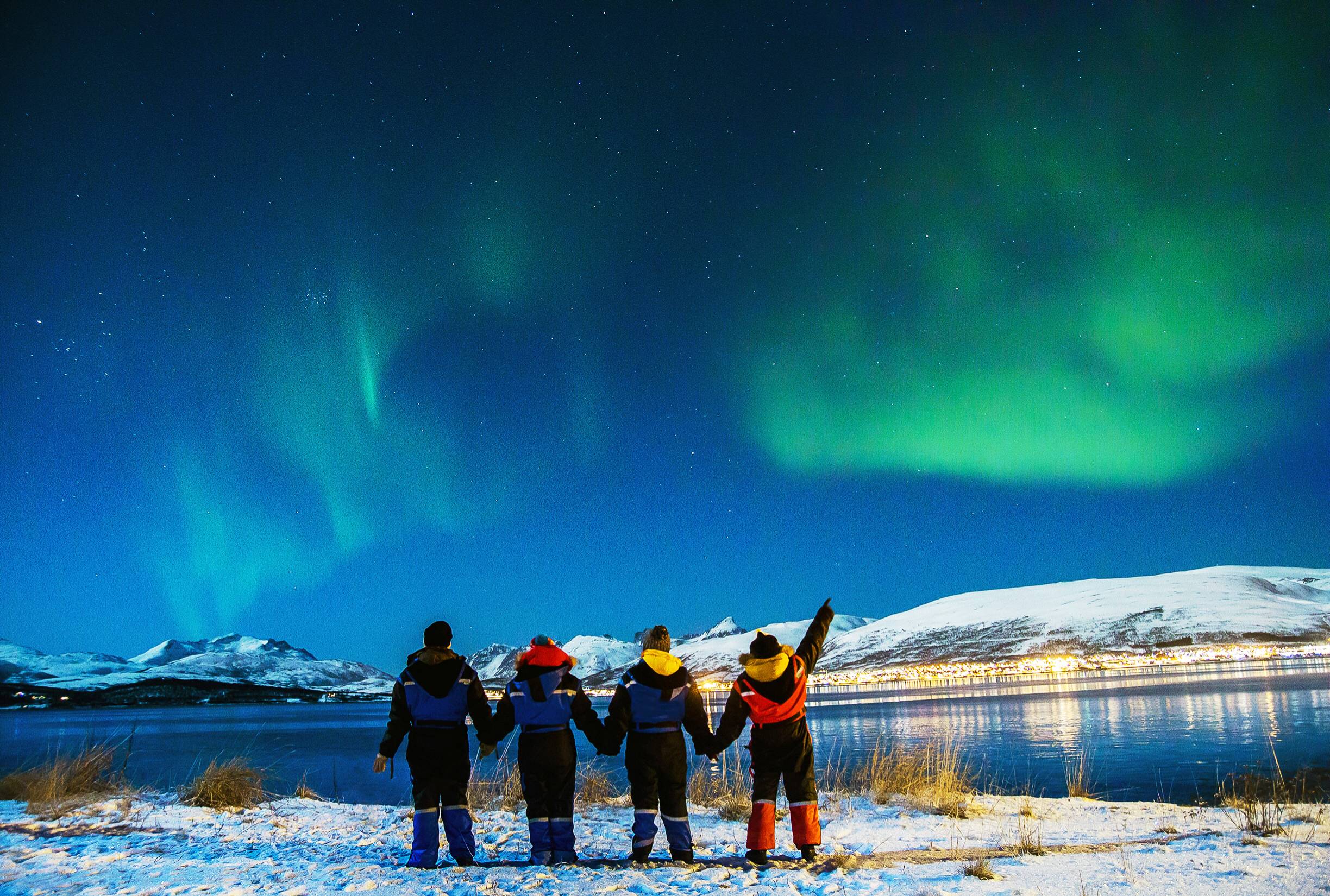 persone si tengono per mano mentre guardano l aurora boreale