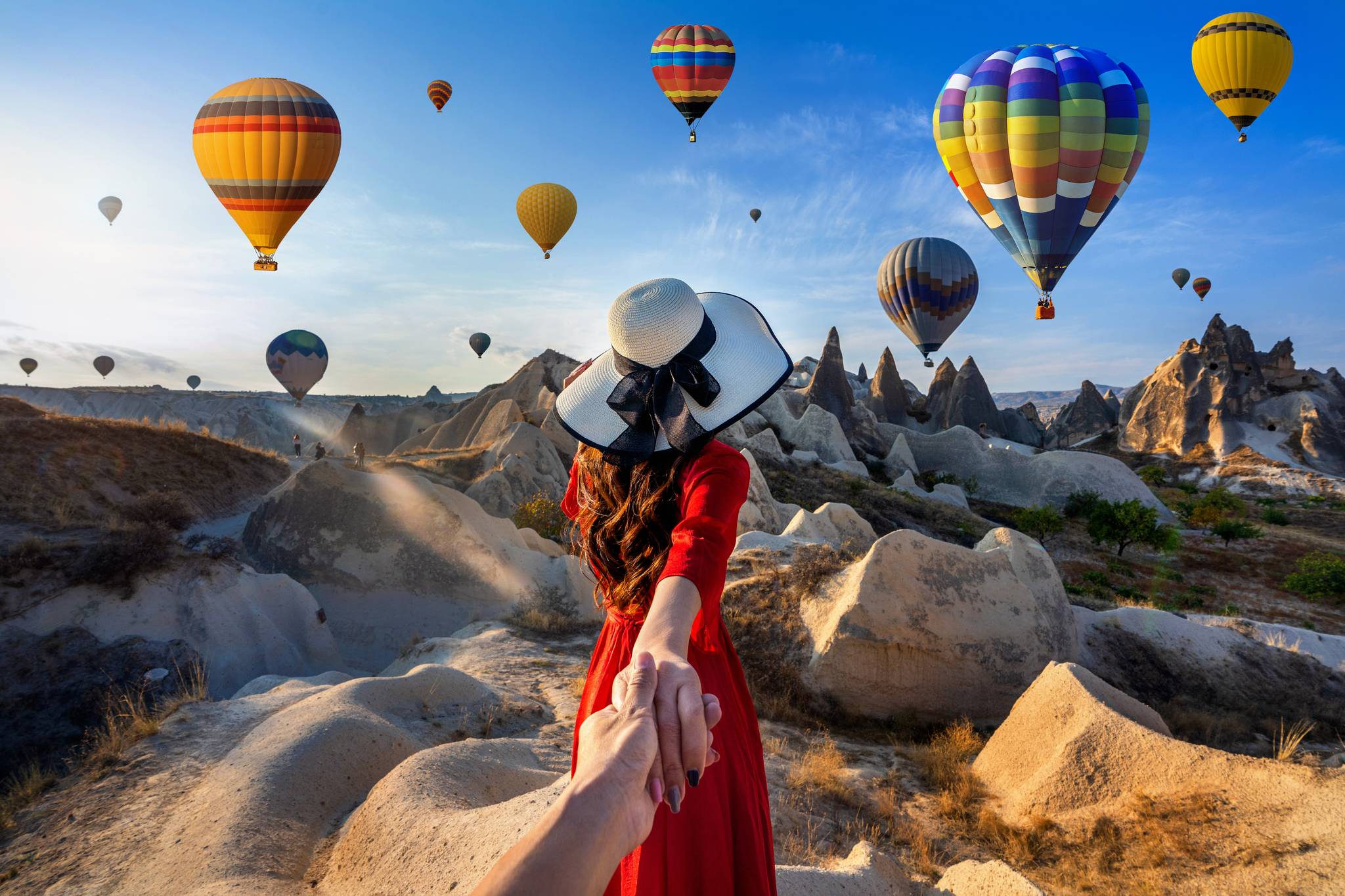 ragazza tiene per mano sfondo mongolfiere cappadocia