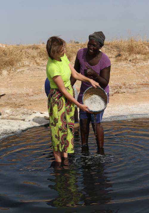 turista e donna senegalese lavorano il riso insieme