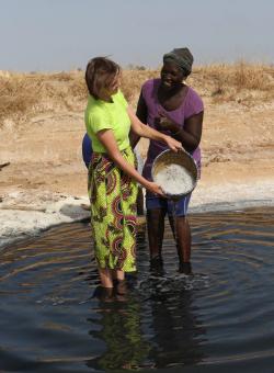 turista e donna senegalese lavorano il riso insieme