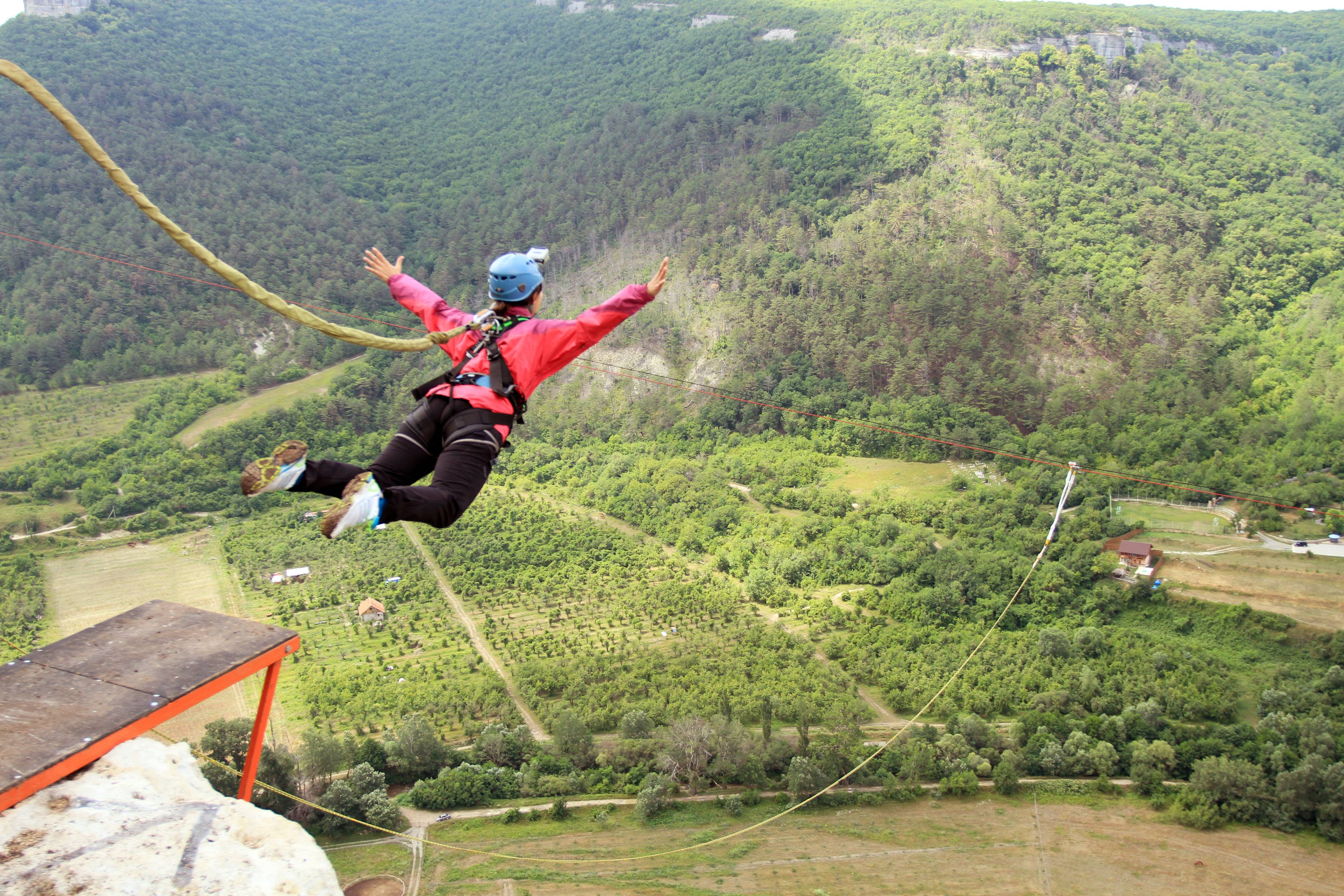 donna fa bungee jumping tra le colline verdi