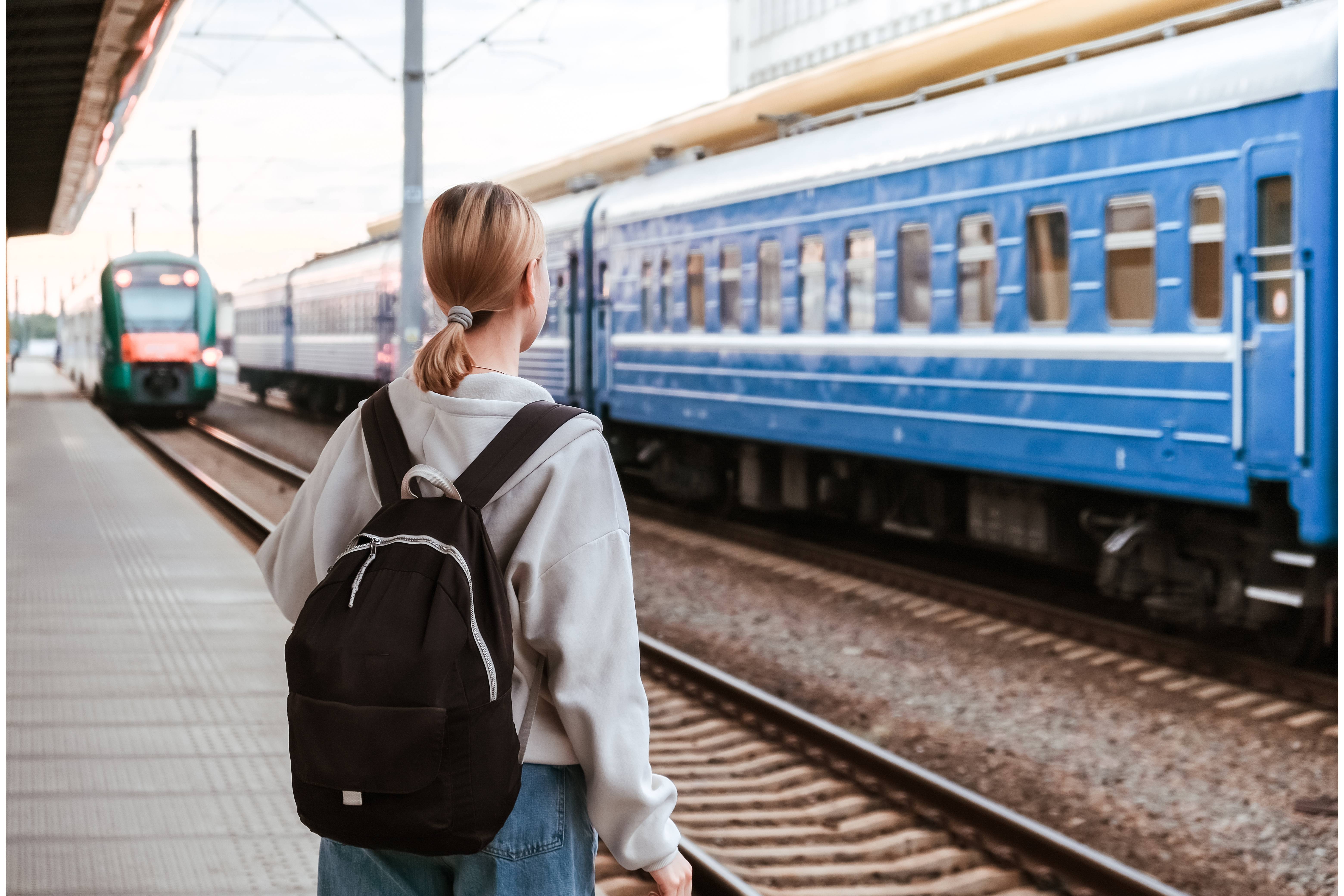 ragazza di spalle che aspetta un treno