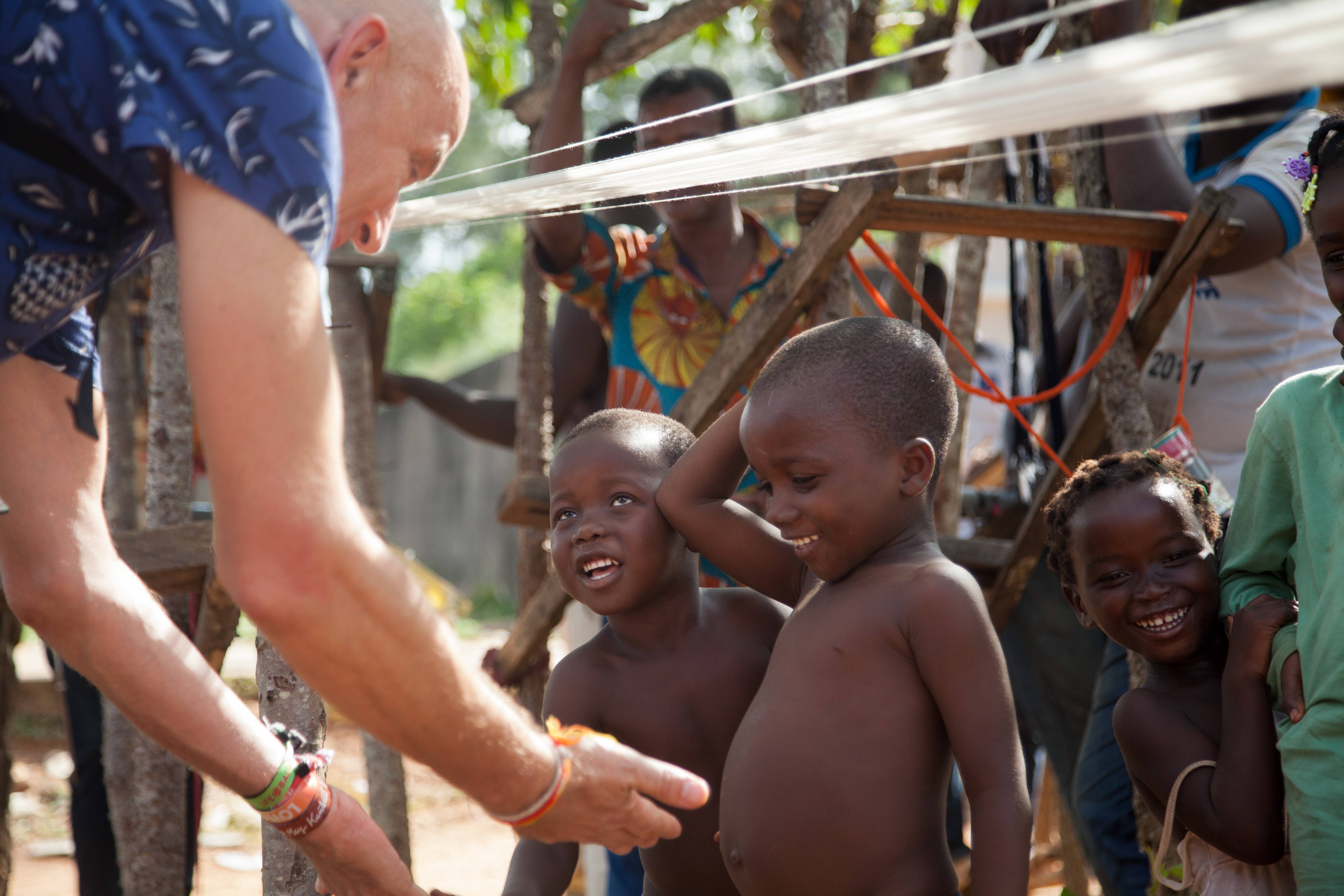 bambini africani battono il cinque a un turista occidentale