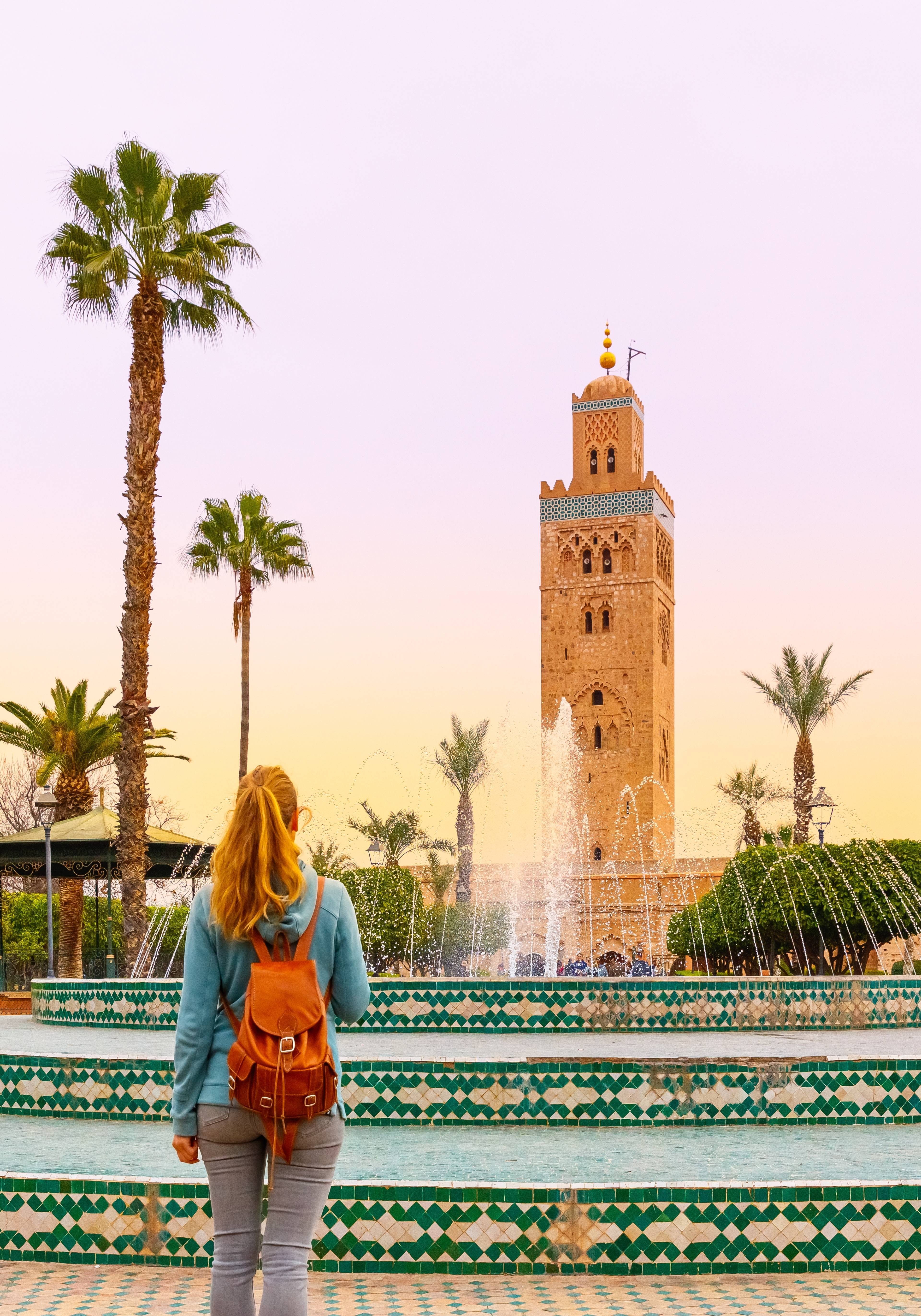 piazza con fontana e ragazza di spalle a marrakech