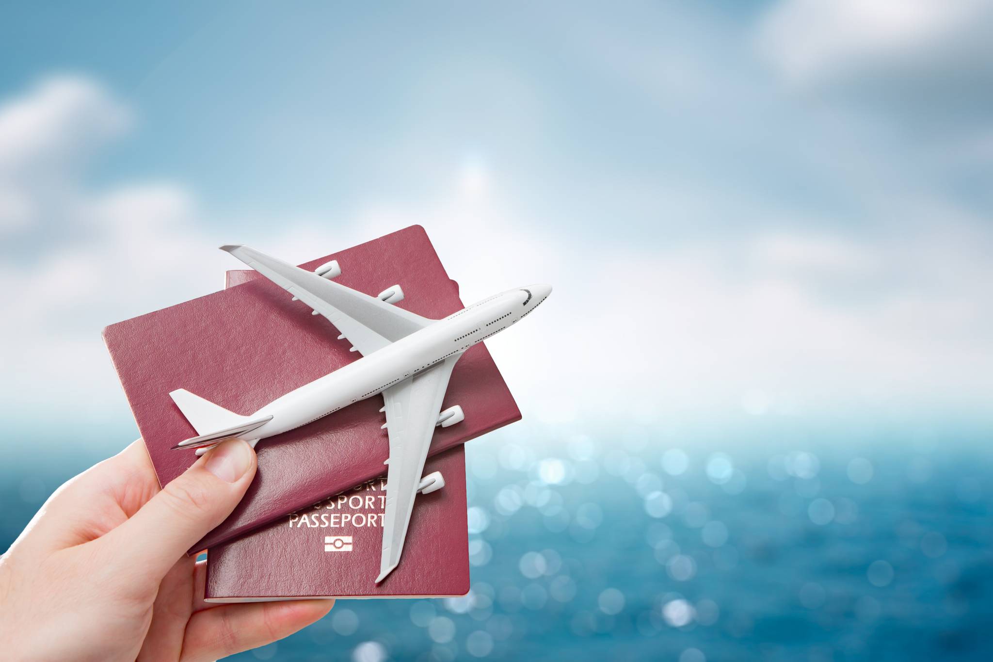mano che tiene in mano passaporti e la miniatura di un aereo