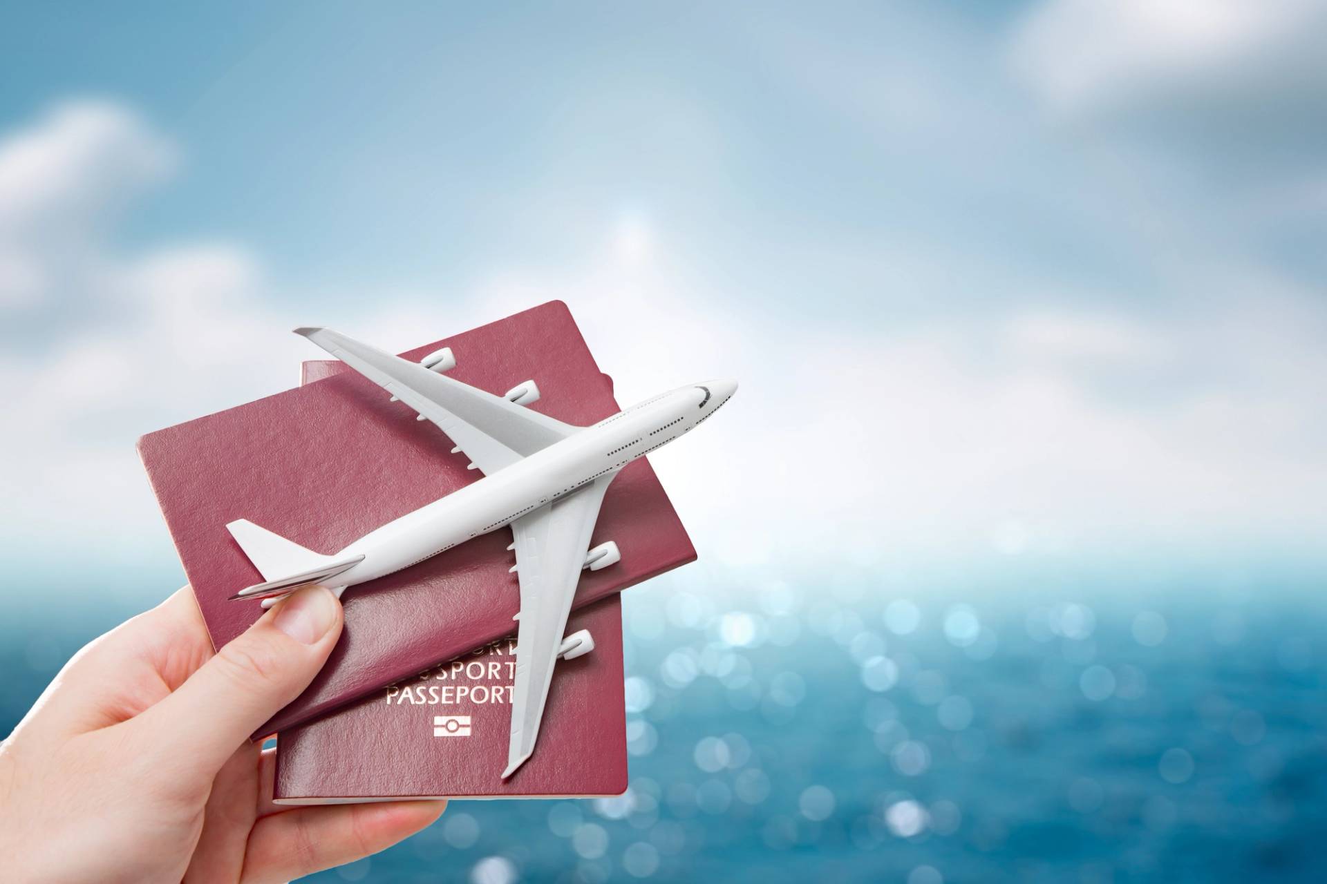mano che tiene in mano passaporti e la miniatura di un aereo