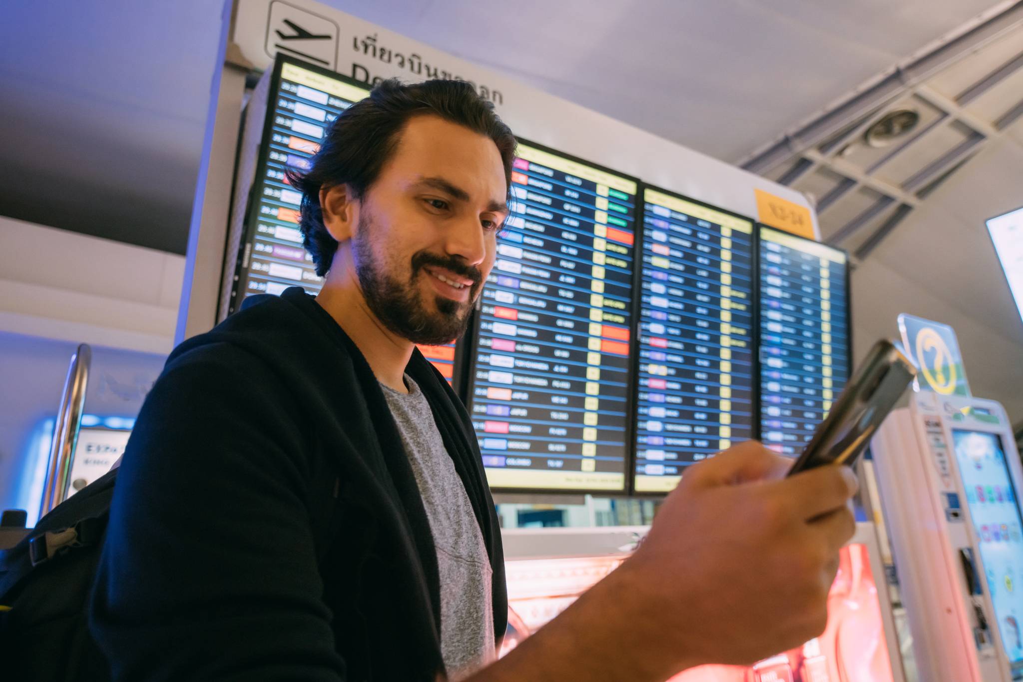 ragazzo in aeroporto guarda tabellone voli