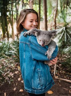 donna con in braccio koala in australia