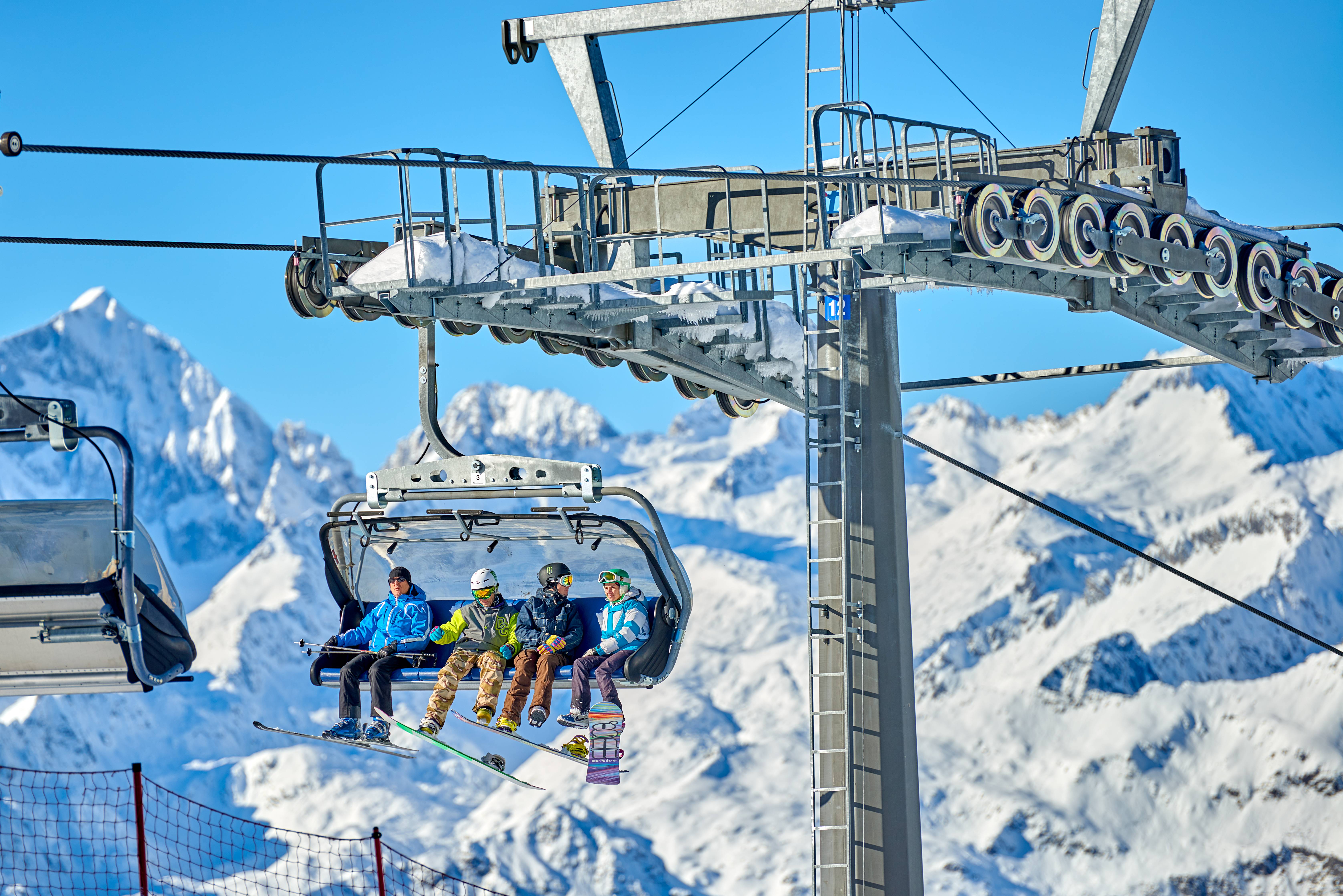 gruppo di sciatori su seggiovia in montagna