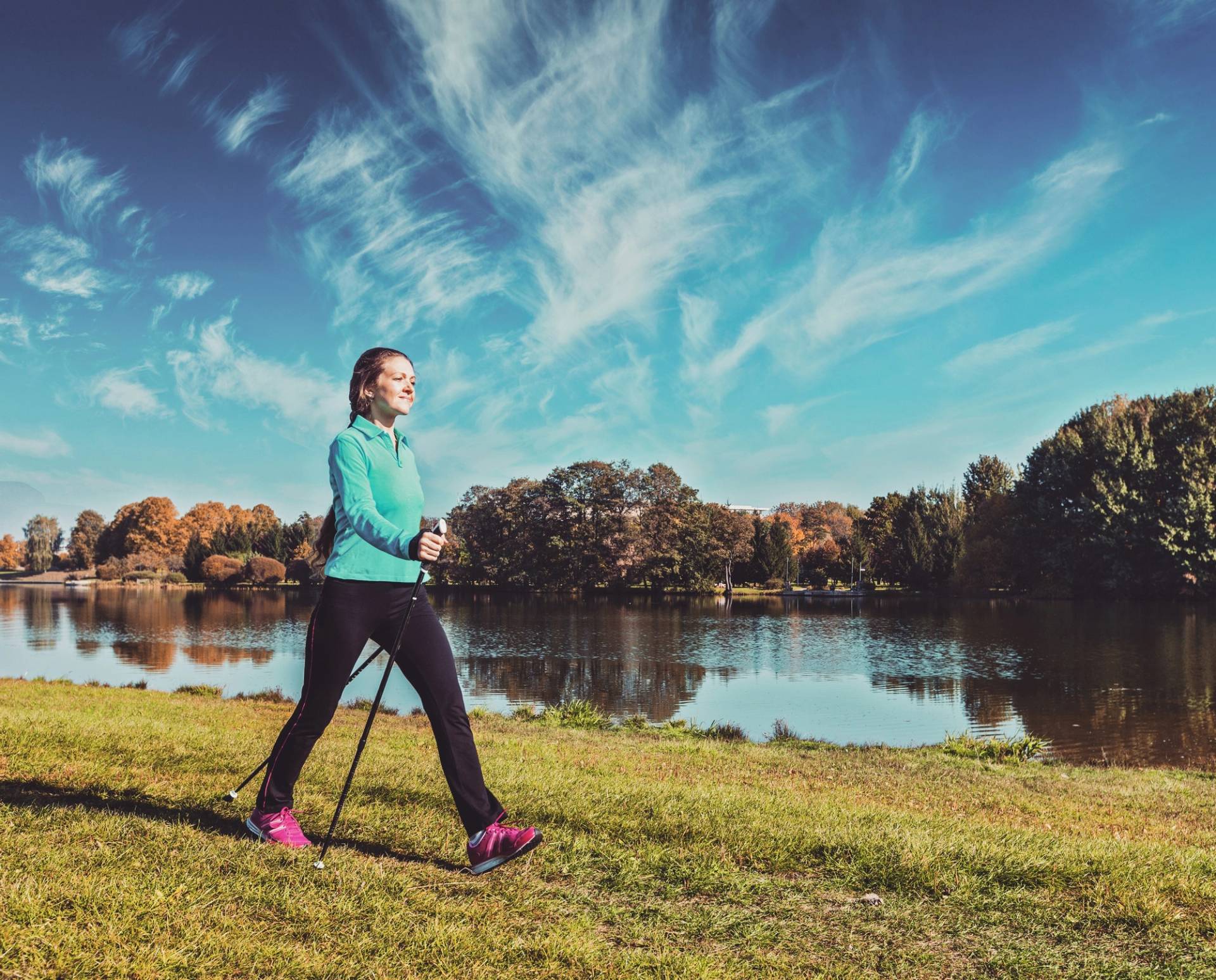 Donna che pratica nordic walking nei pressi di un lago