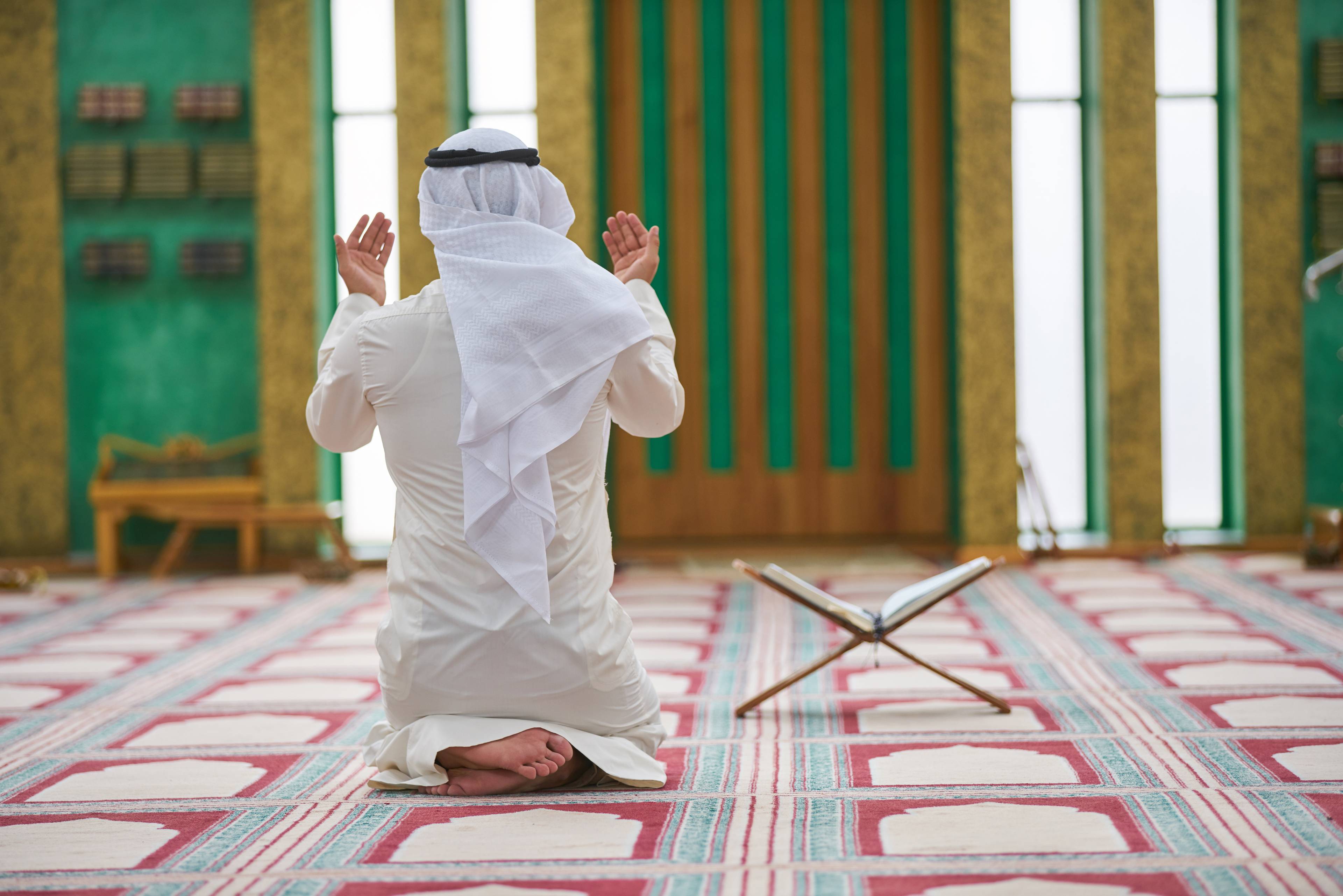 uomo islamico prega in moschea con corano