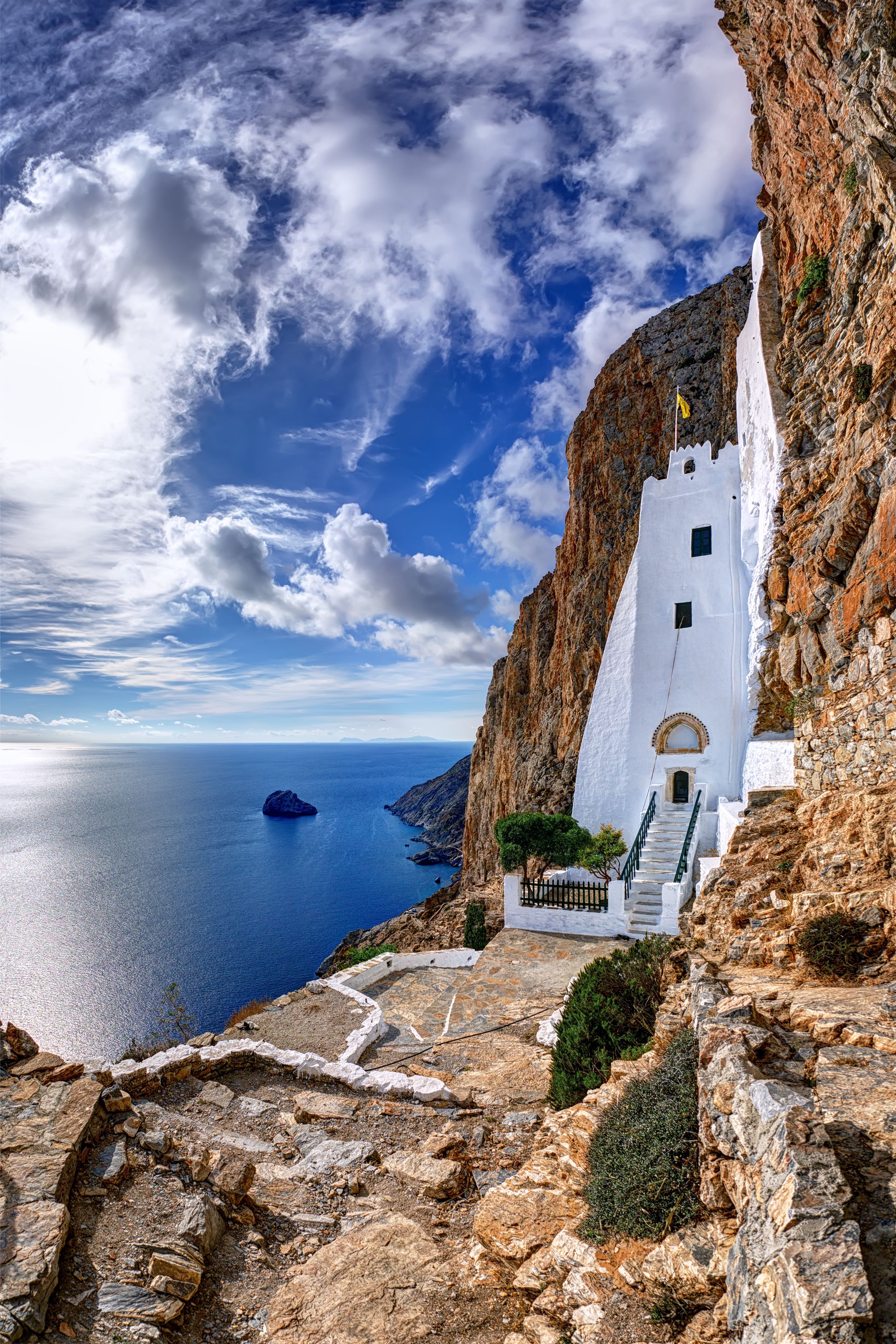 white house nestled in the rock with sea