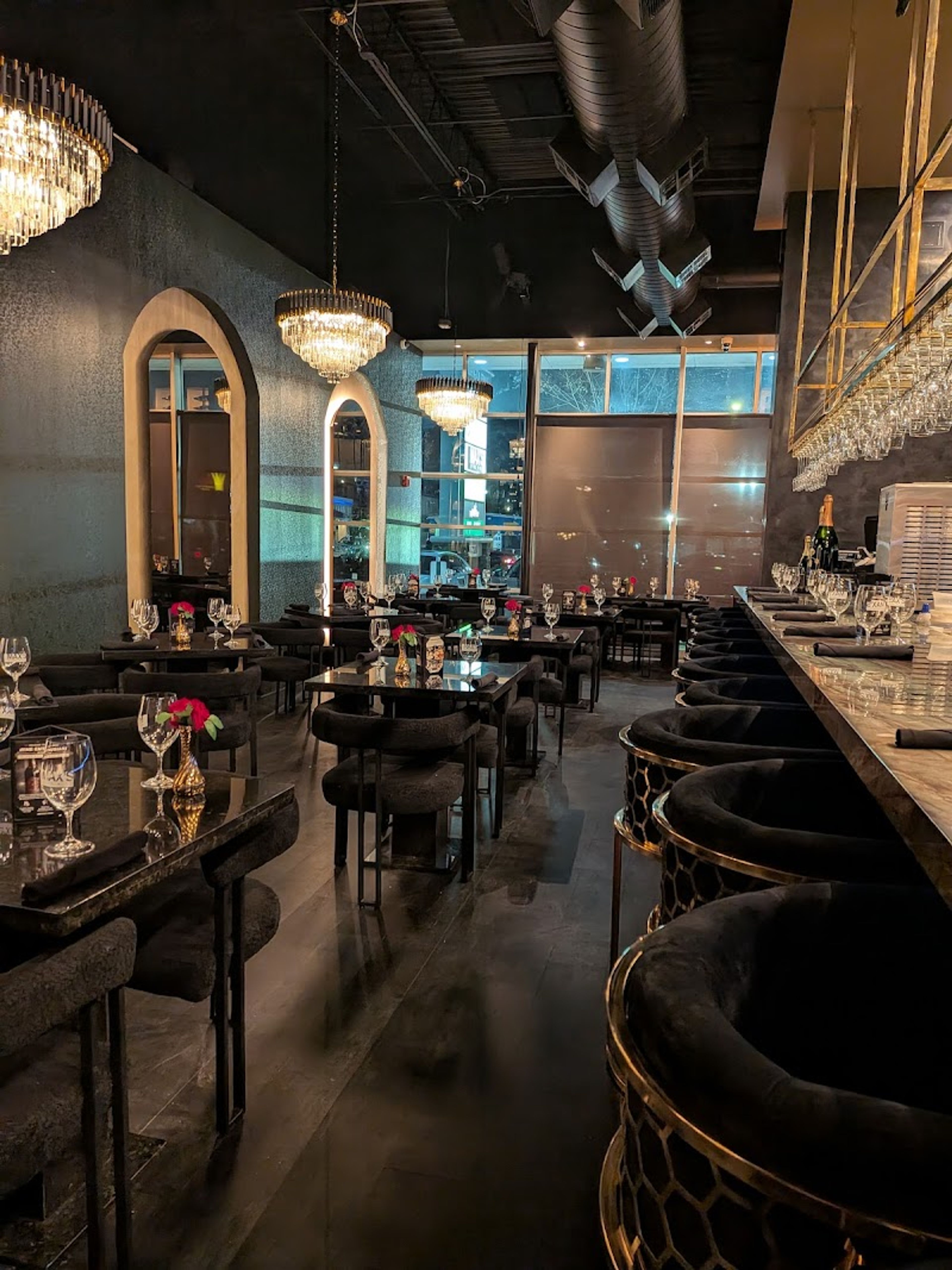The bar with chairs, overhead lighting, and tables
