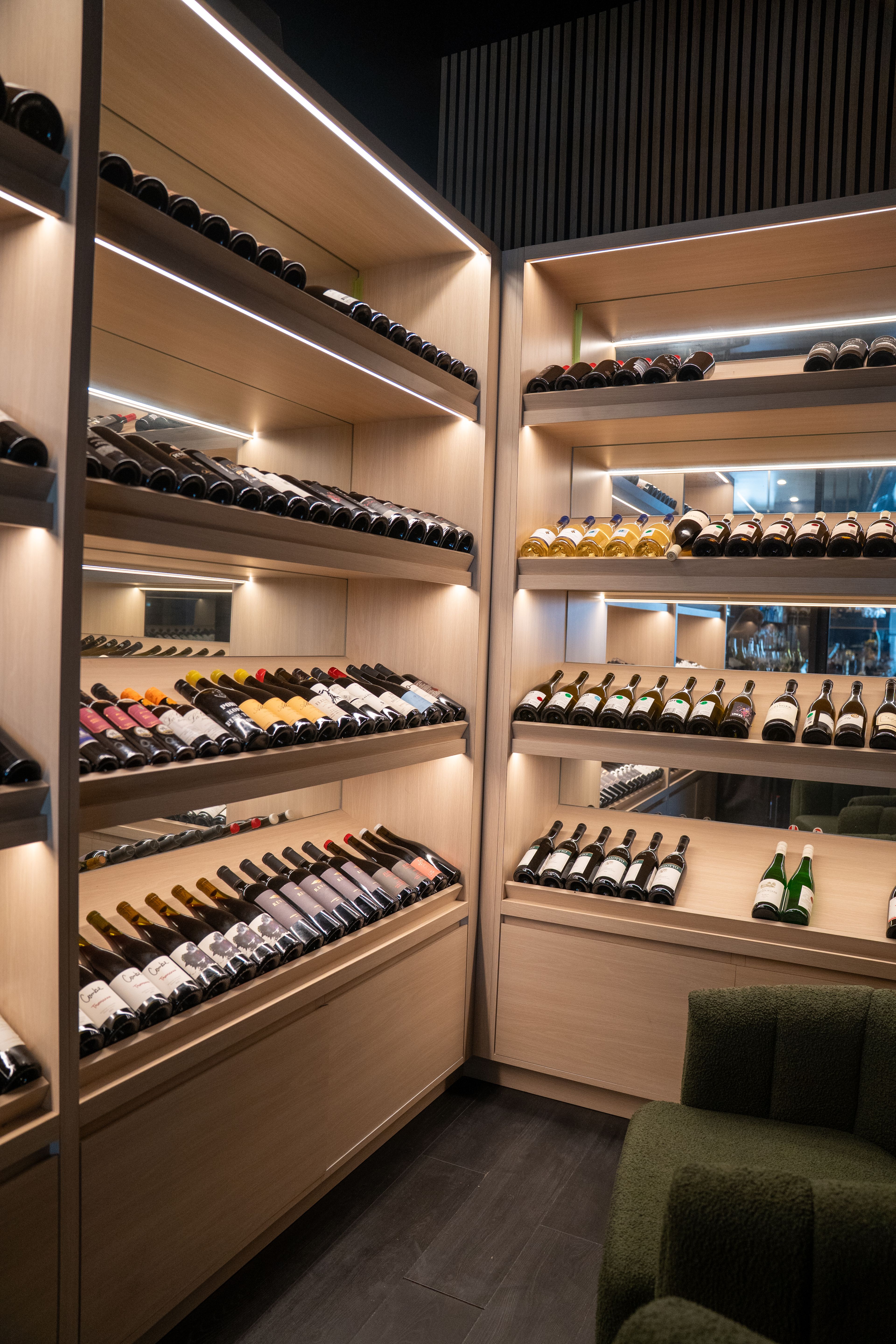 Wine bottles on lit wooden shelves