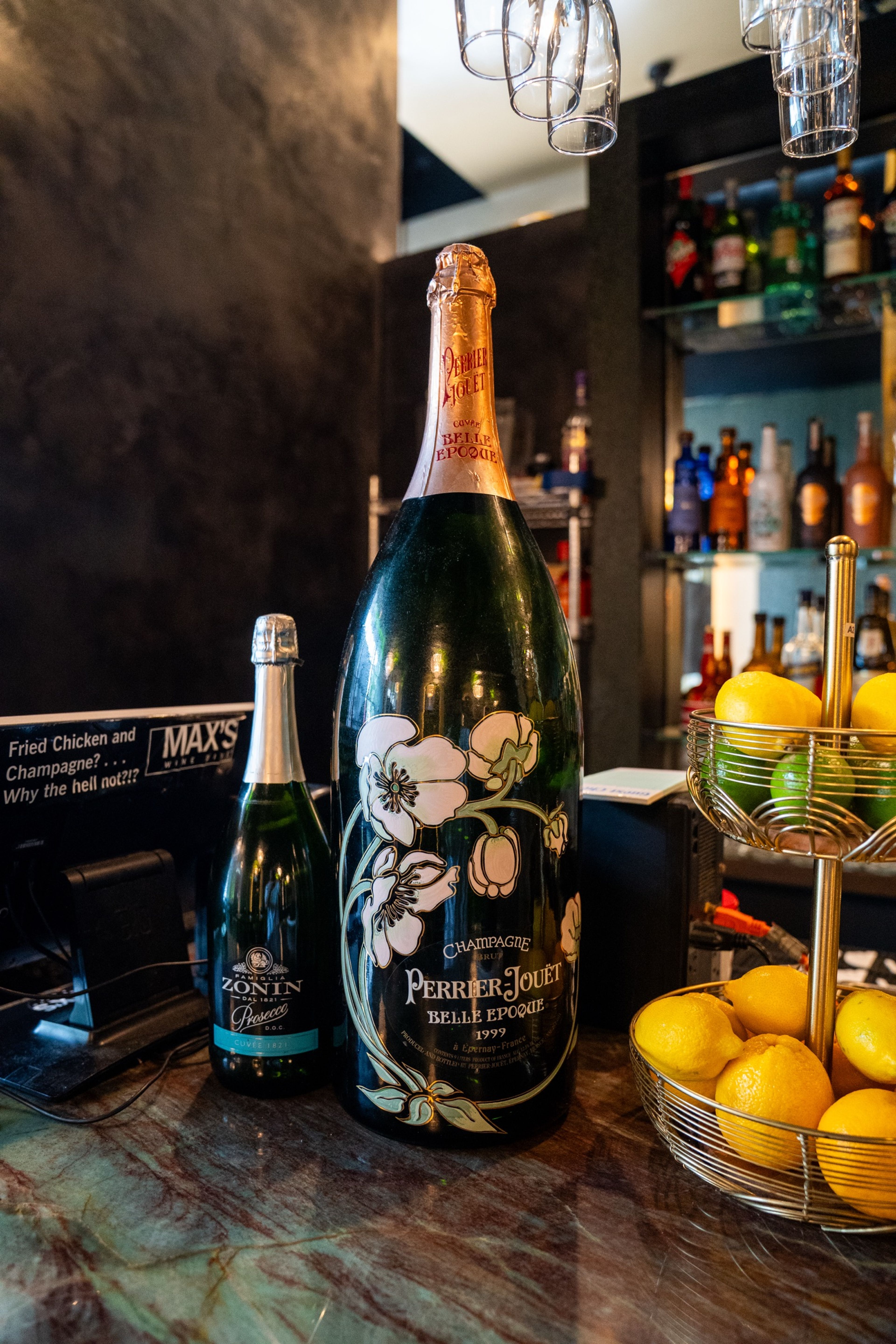 Champagne bottles on the bar beside a chalkboard sign