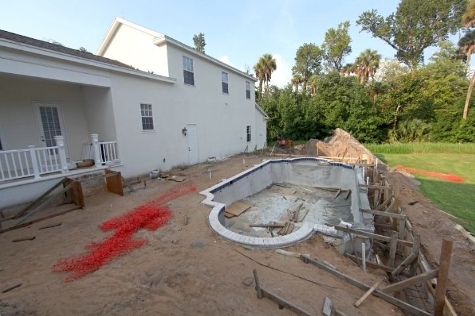 New inground pool construction in progress with exposed shell and surrounding excavation