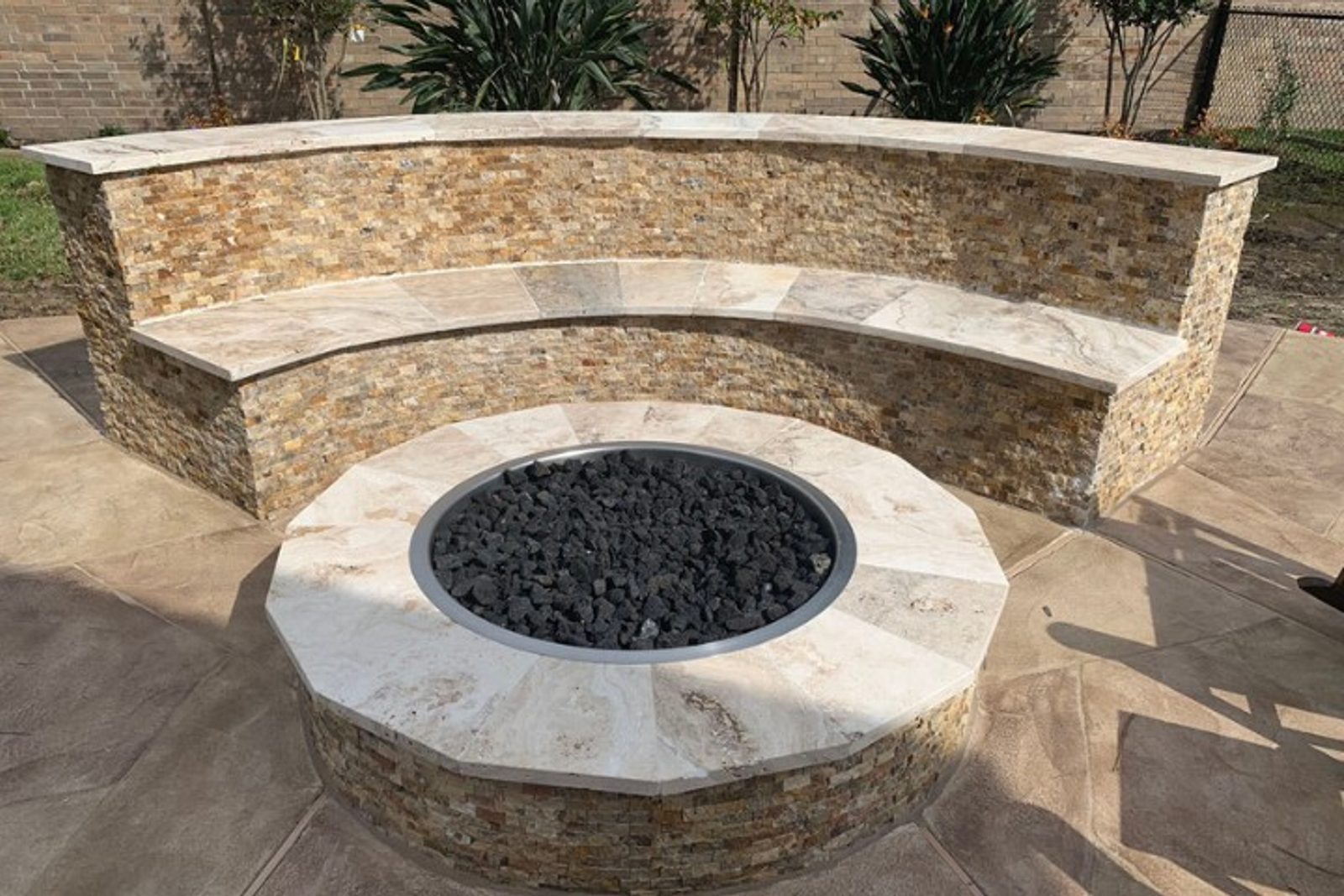 Classic patio feature combining built-in stone wall seating and fire pit