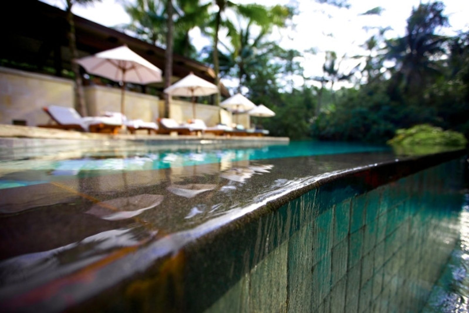 Close-up view of water flowing over an infinity pool spillway edge