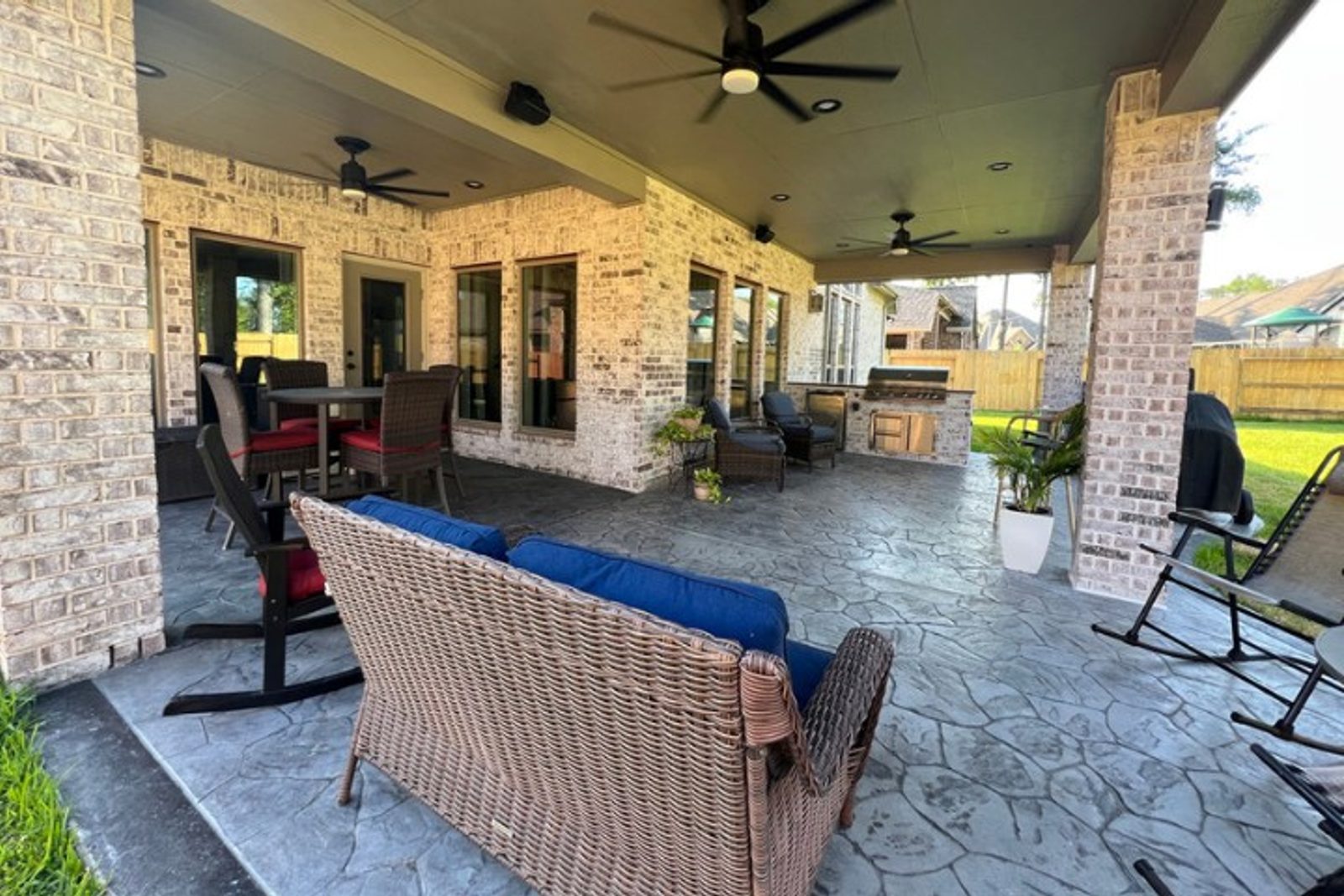 Covered patio with wicker seating and cushions, designed for timeless style and comfort