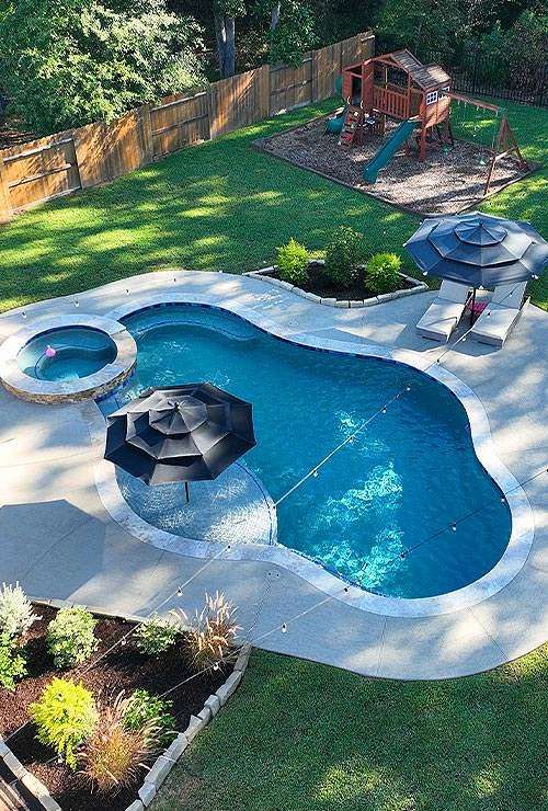 Luxury custom pool with spa and lounge chairs perfect for family outdoor living in Houston