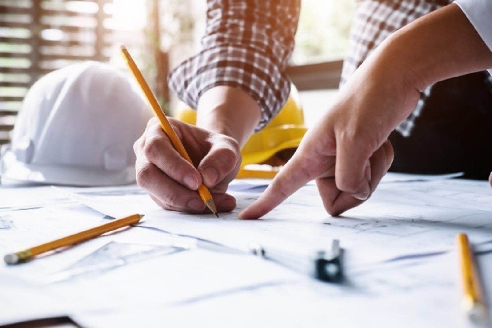 Pool contractor and homeowner reviewing blueprints before beginning a custom pool build