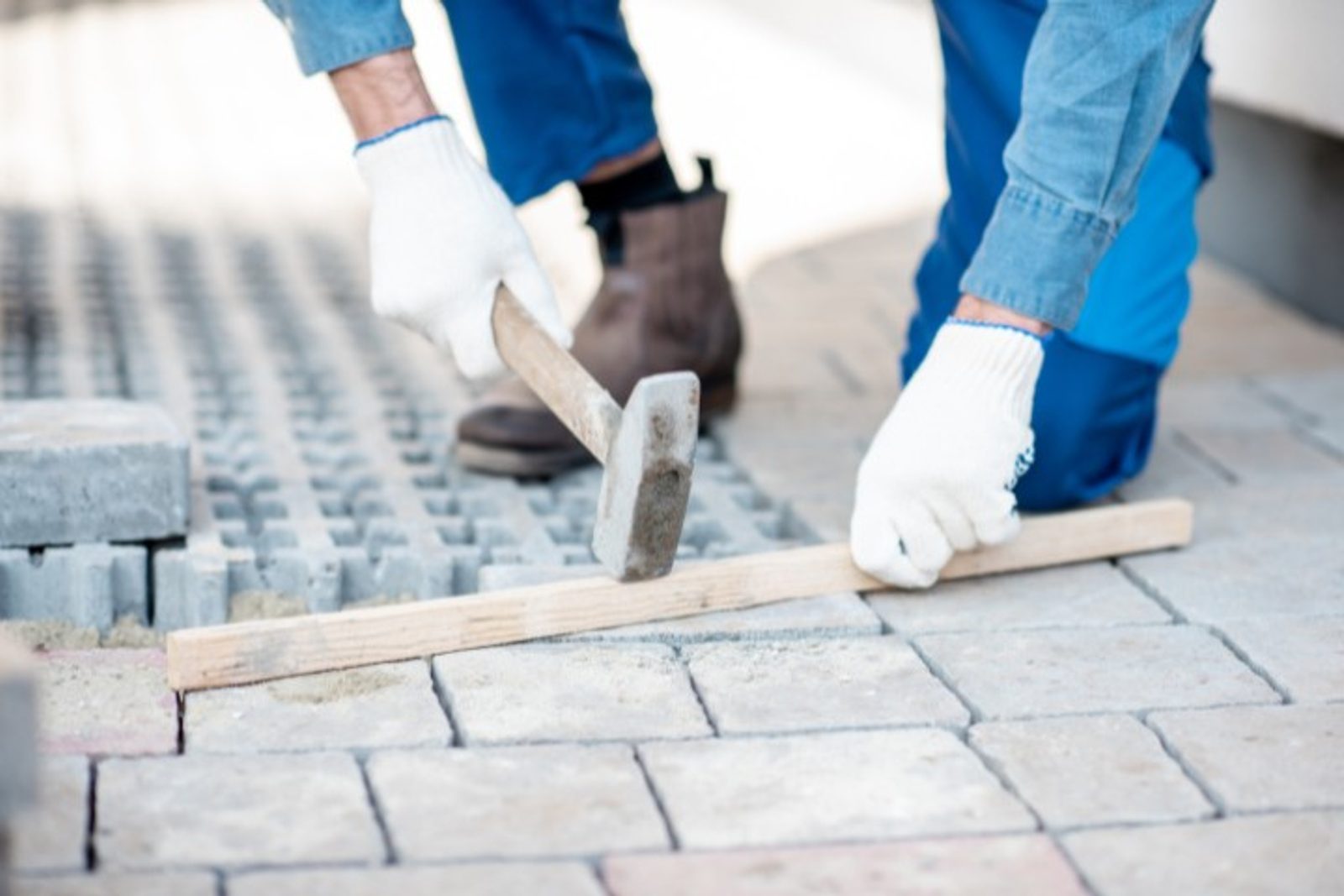 Pool builder installing patio pavers for custom pool design