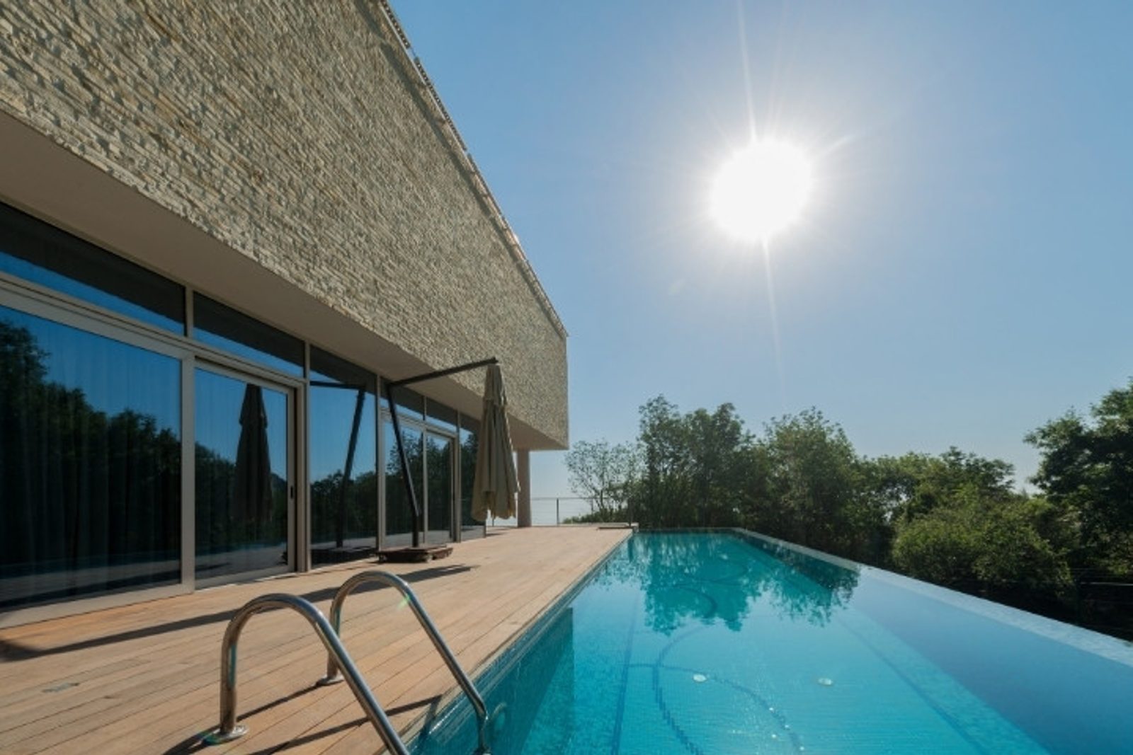 Pool deck designed to complement a vanishing edge pool
