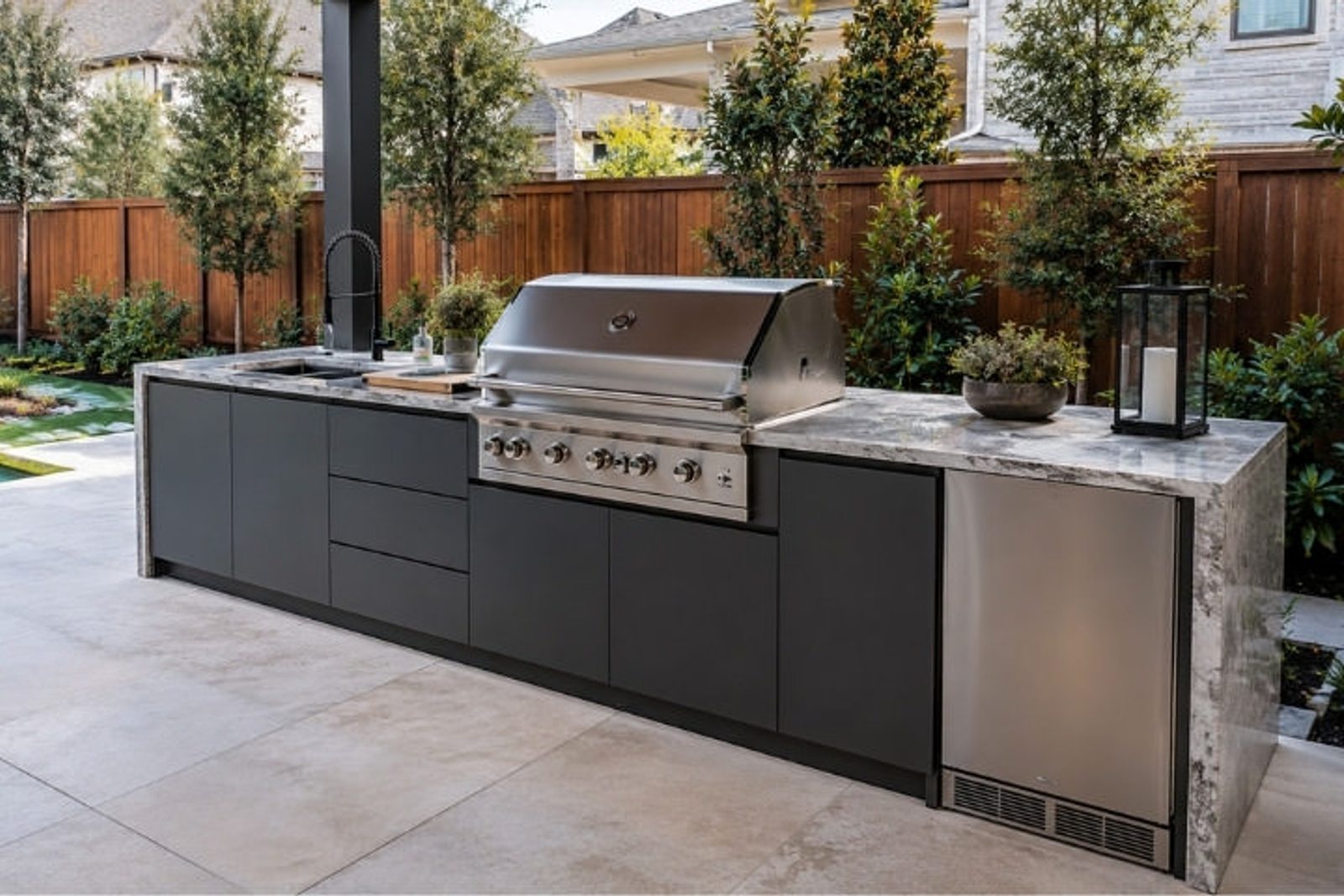 Modern outdoor kitchen with handleless cabinetry, stainless steel grill, and sleek patio design
