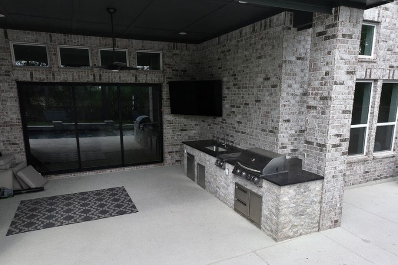 Modern outdoor kitchen with sliding glass doors for seamless indoor-outdoor living.
