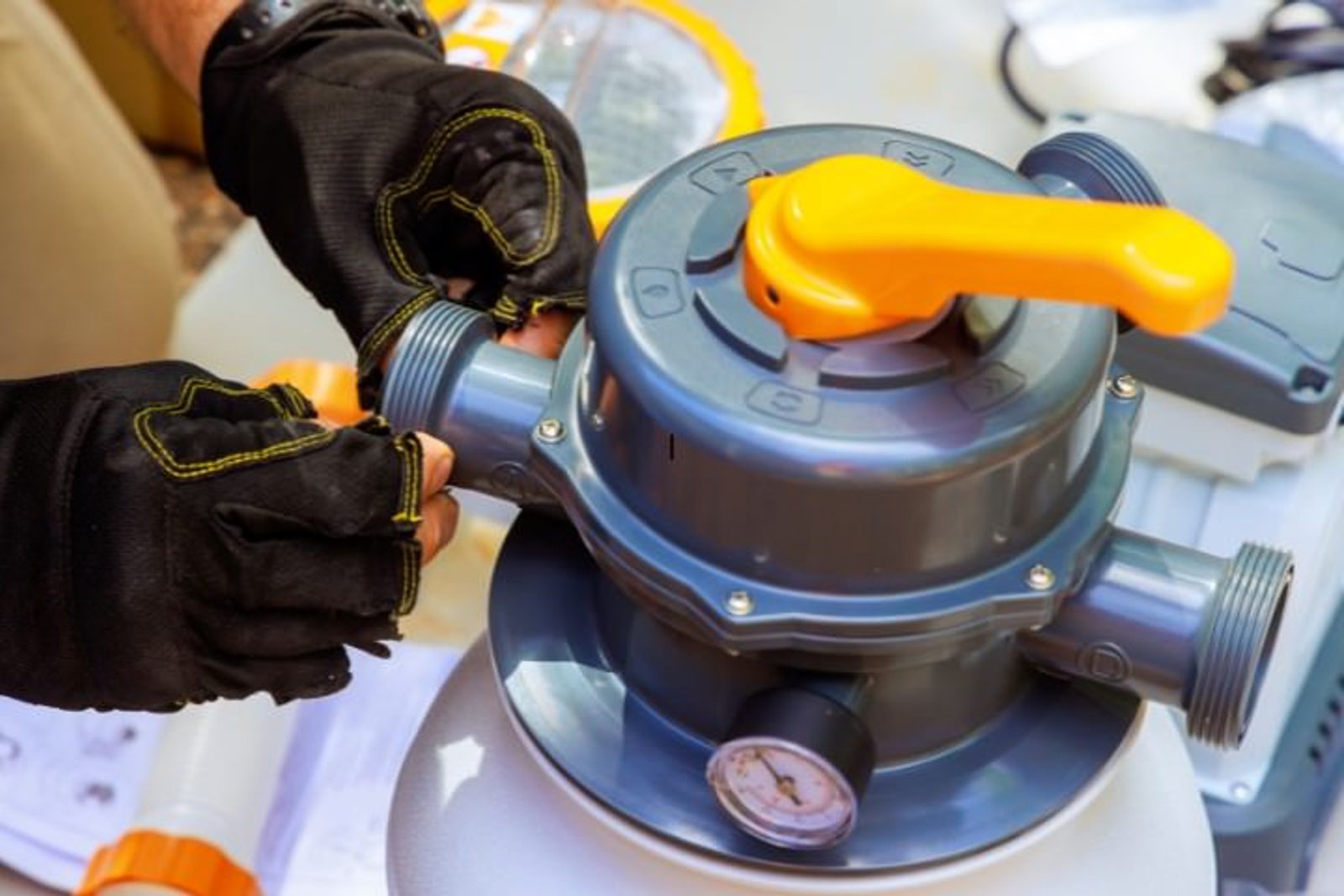 Technician connecting pool pump and filter equipment during mechanical installation phase in pool construction