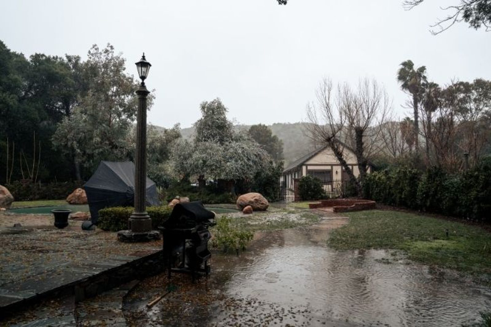Heavy rain causing standing water and flooding around a residential yard