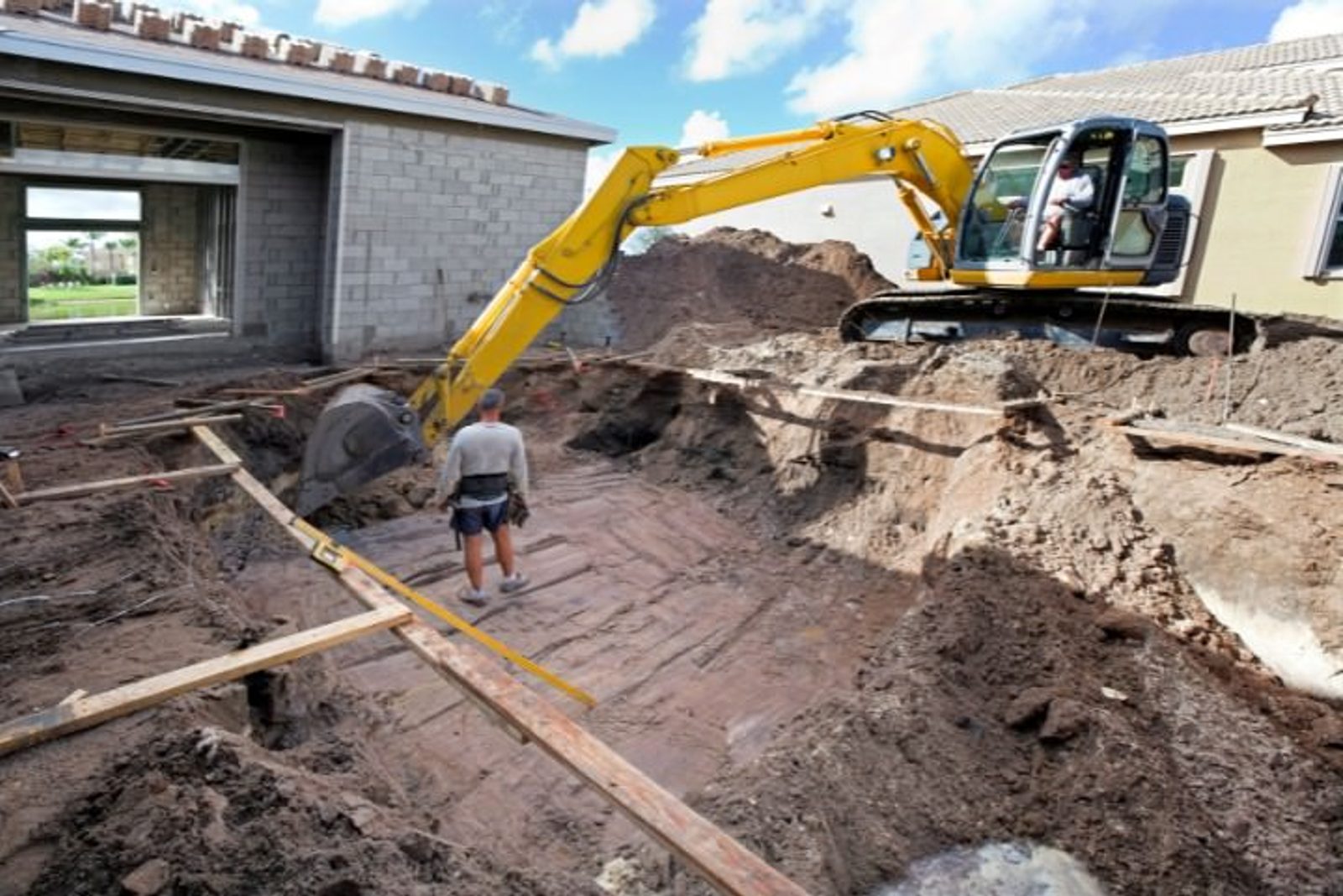 Pool builder overseeing early stages of inground pool installation in Houston