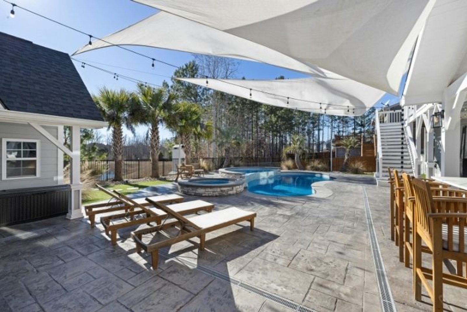 Shade sails covering poolside chaise lounges in Houston