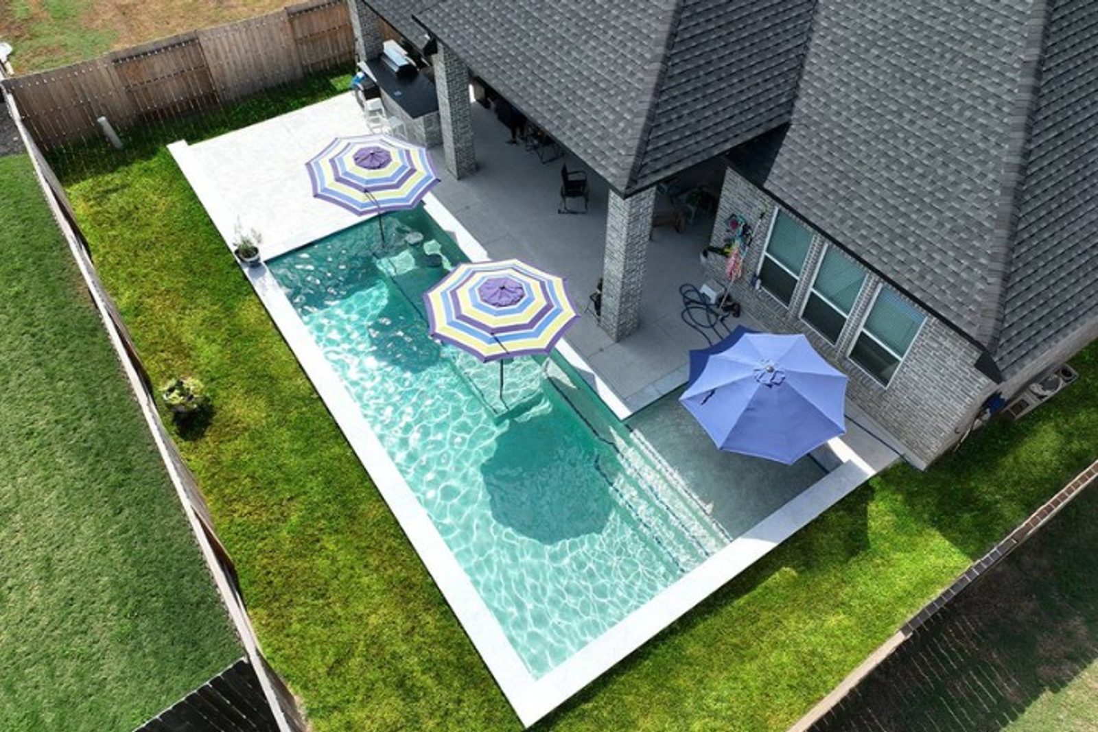 Aerial view of plunge pool with umbrellas in a Houston backyard