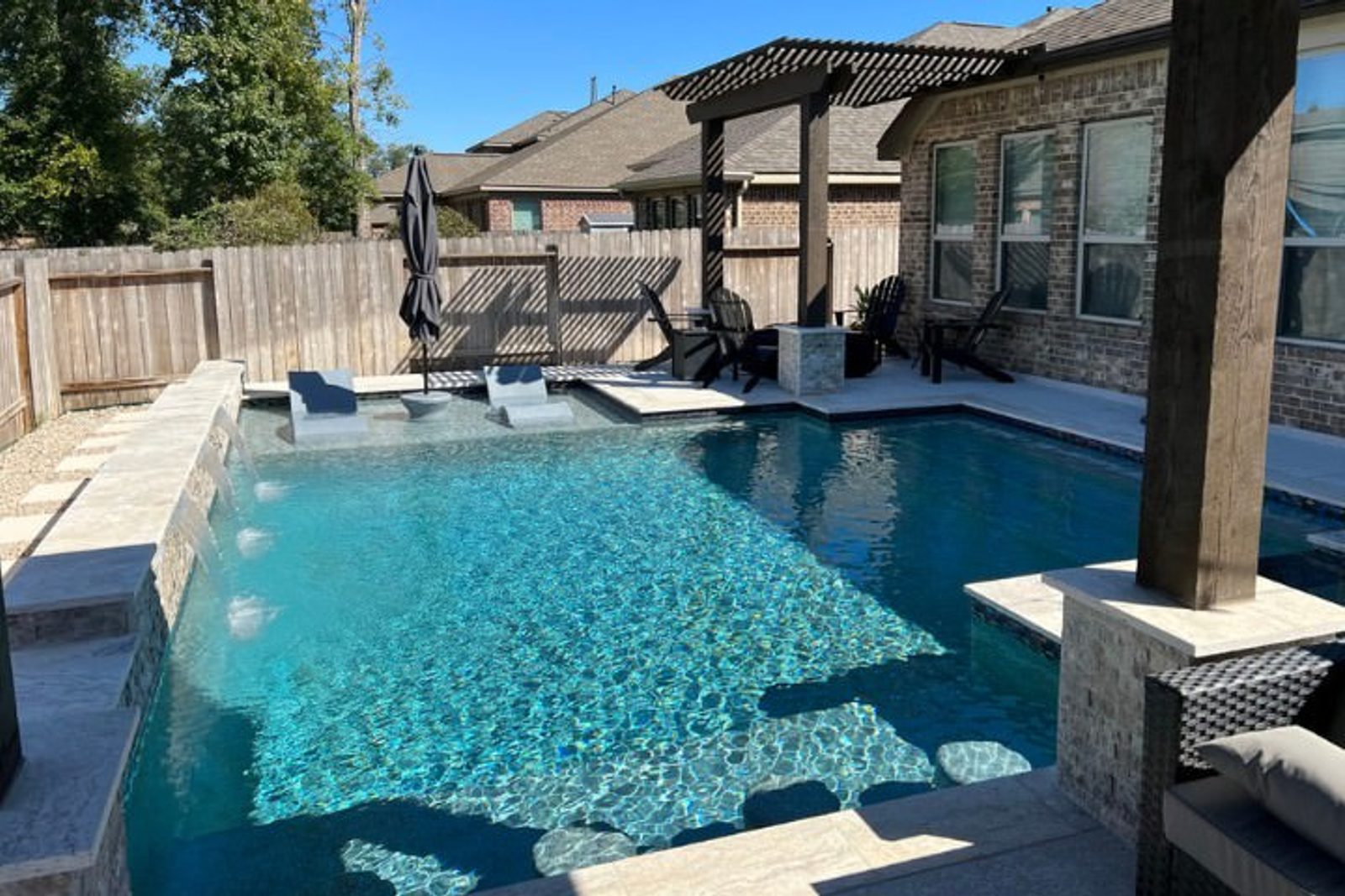 Custom Houston pool with swim-in bar and tanning ledges by GM Outdoor Living Pool & Spa
