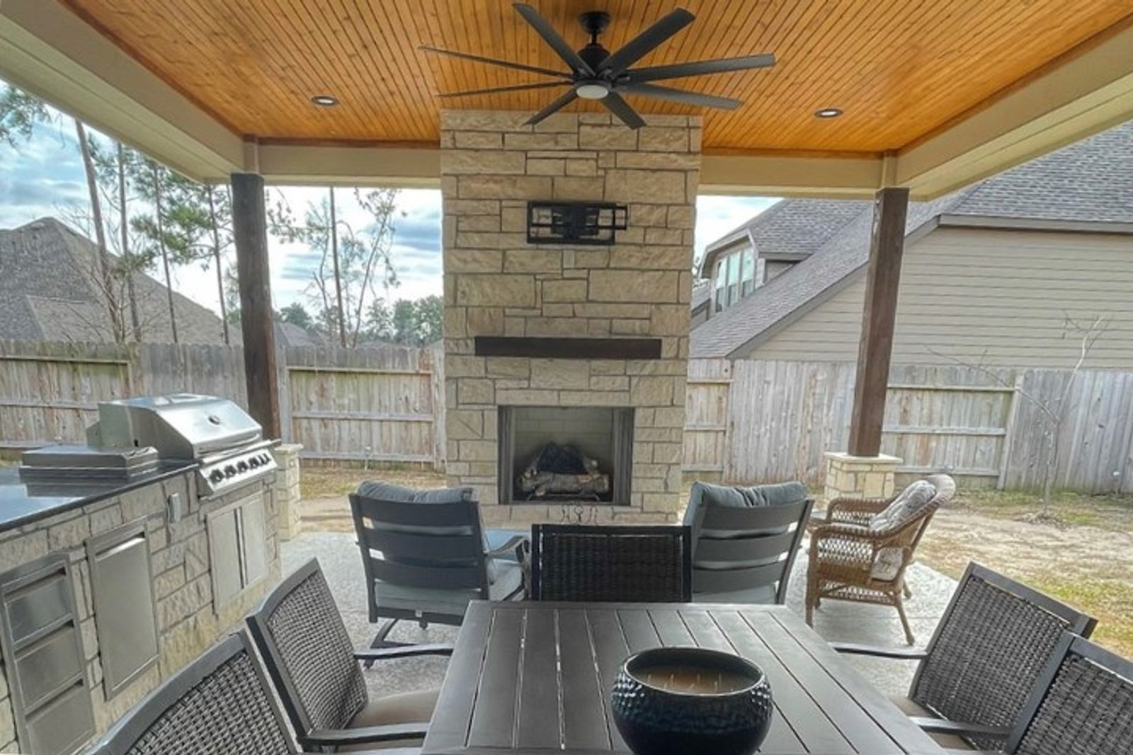 Outdoor kitchen with a built-in fireplace and comfortable seating area