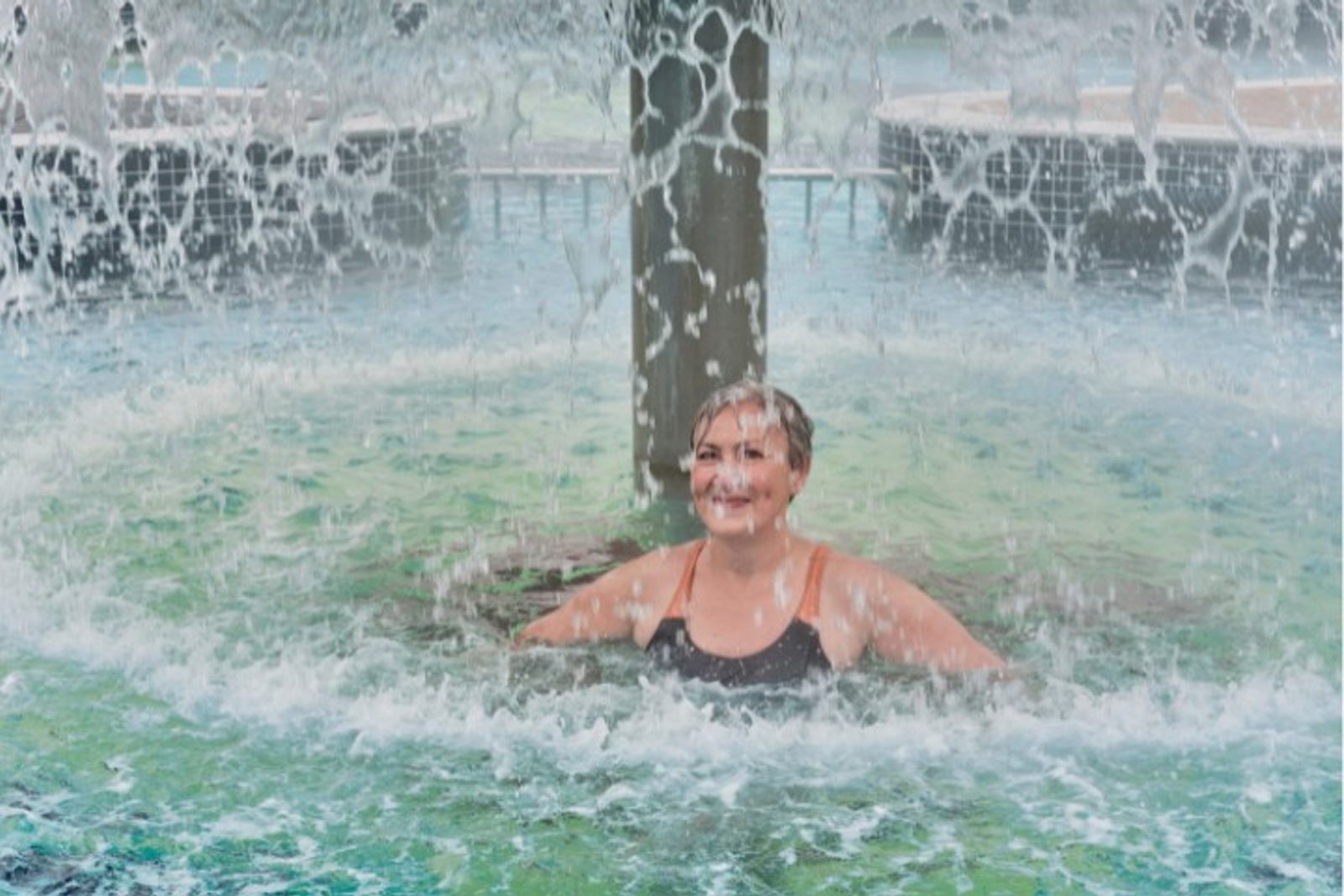 Houston homeowner enjoying a pool waterfall feature for relaxation and cooling