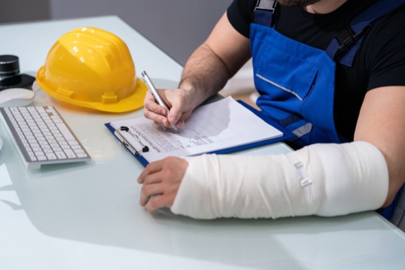 Construction worker completing insurance paperwork with an injured arm
