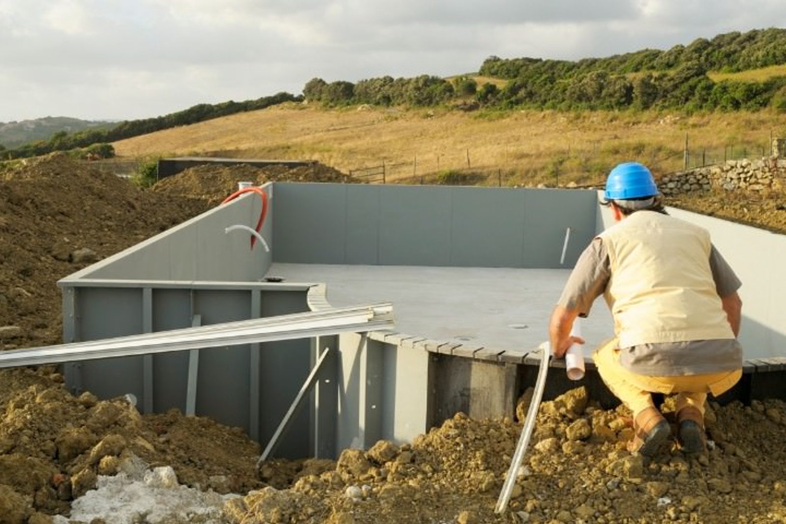 Contractor reviewing inground pool site progress