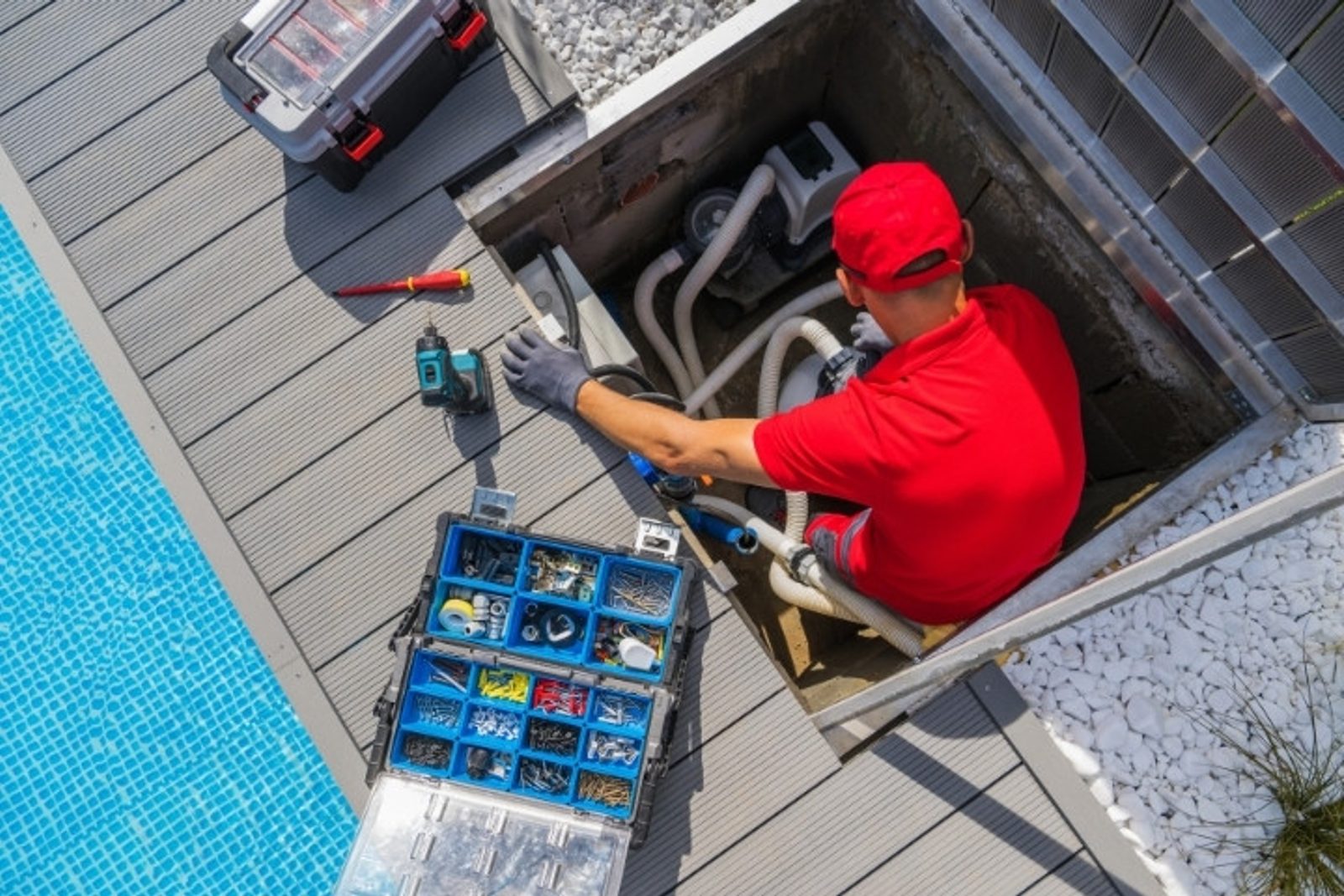 Houston pool technician accessing equipment area for infinity pool maintenance and servicing